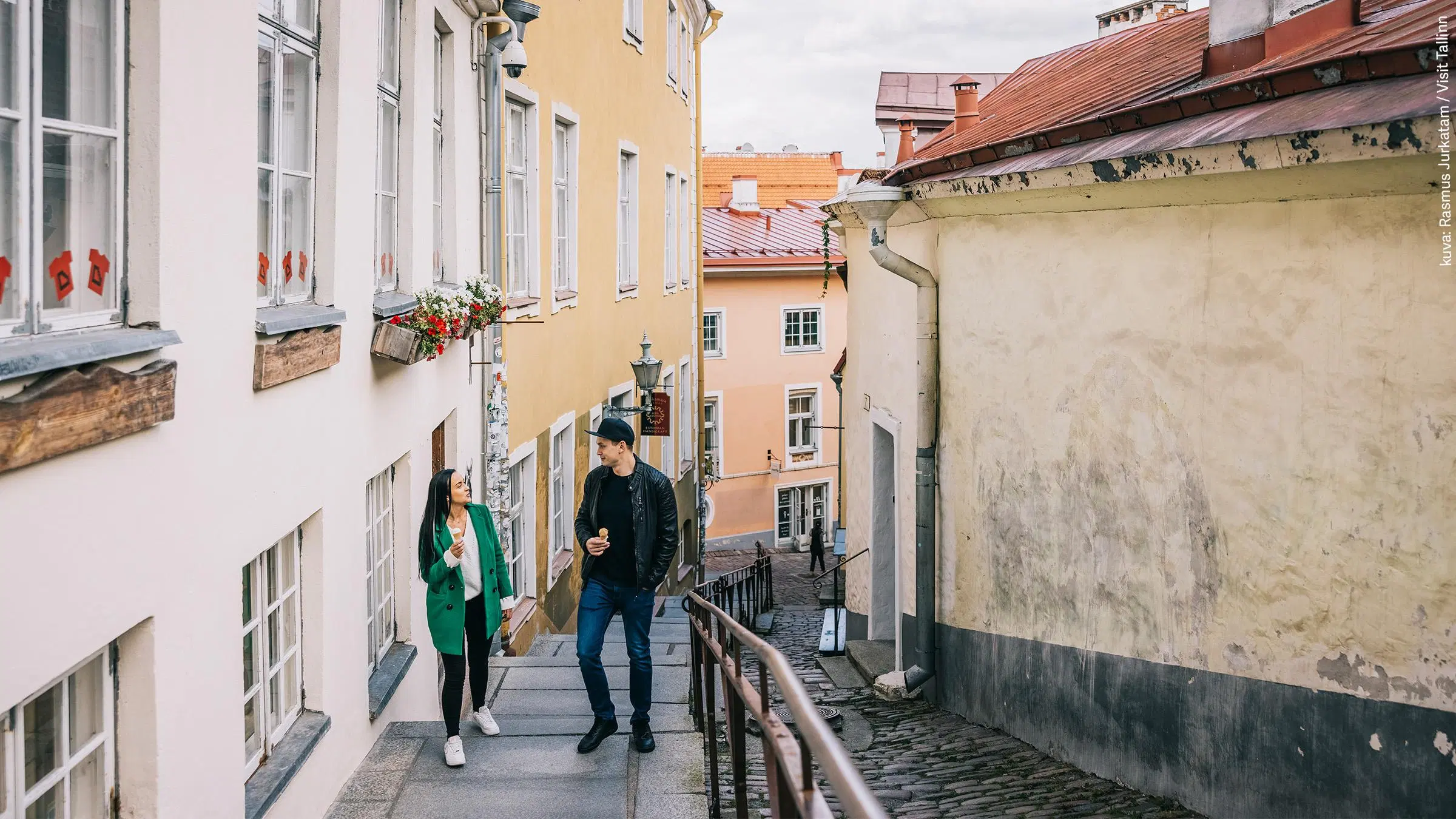 Nuori pariskunta kävelemässä Tallinnan vanhan kaupungin kujilla.