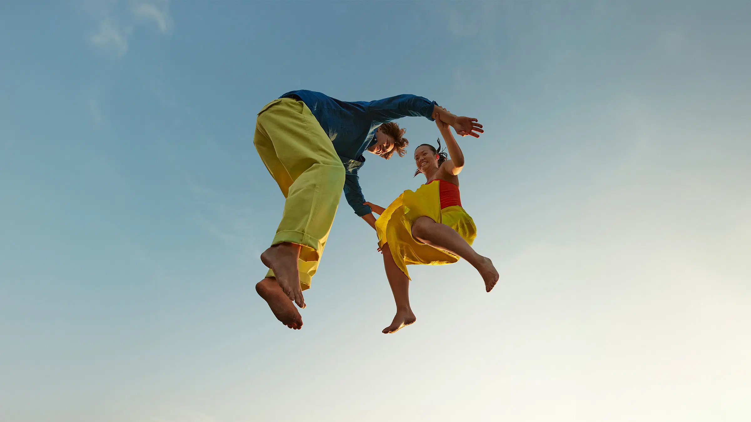 Kaksi ihmistä hyppää ilmaan.