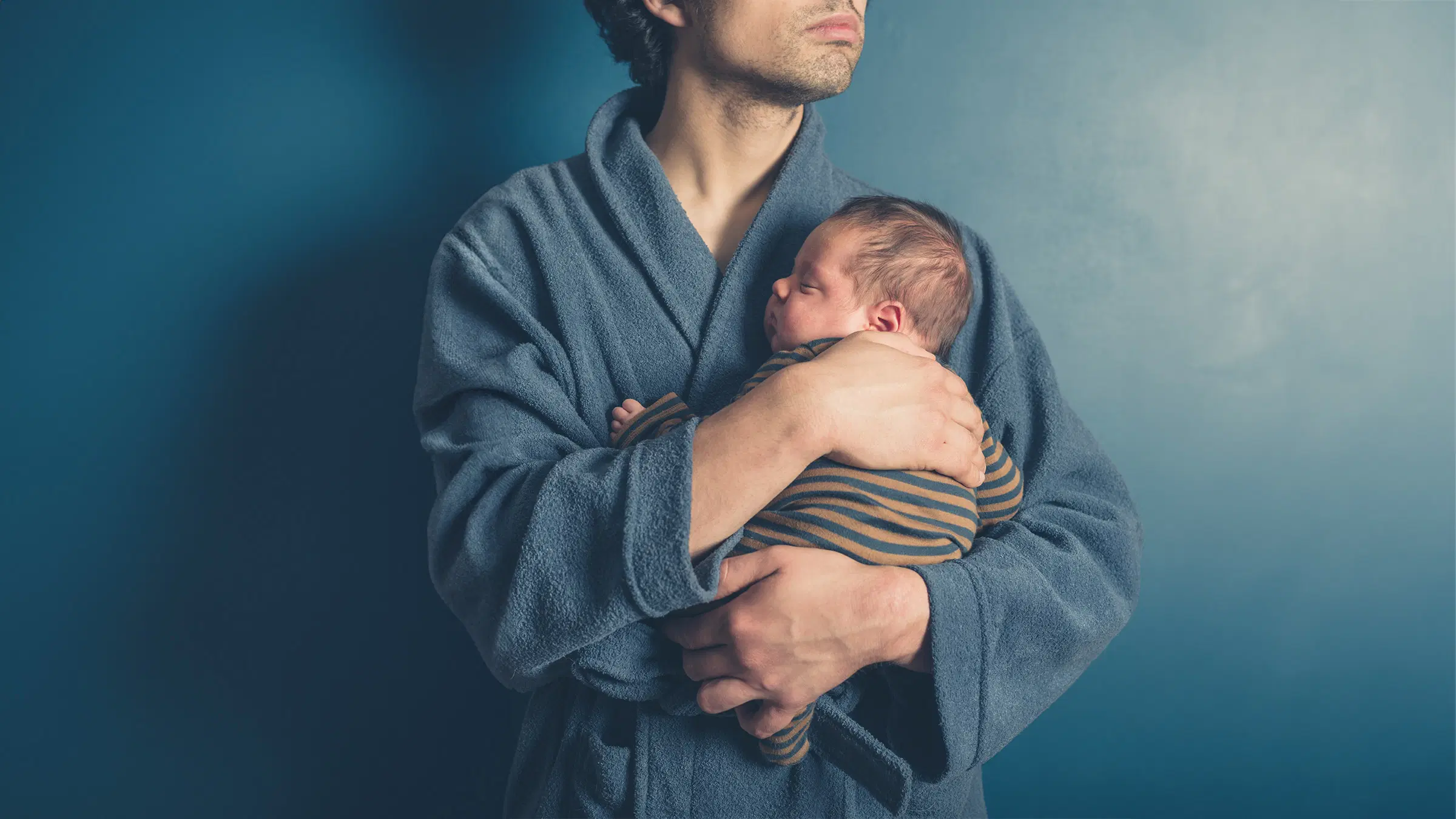 Mies pitelee pientä vauvaa sylissään