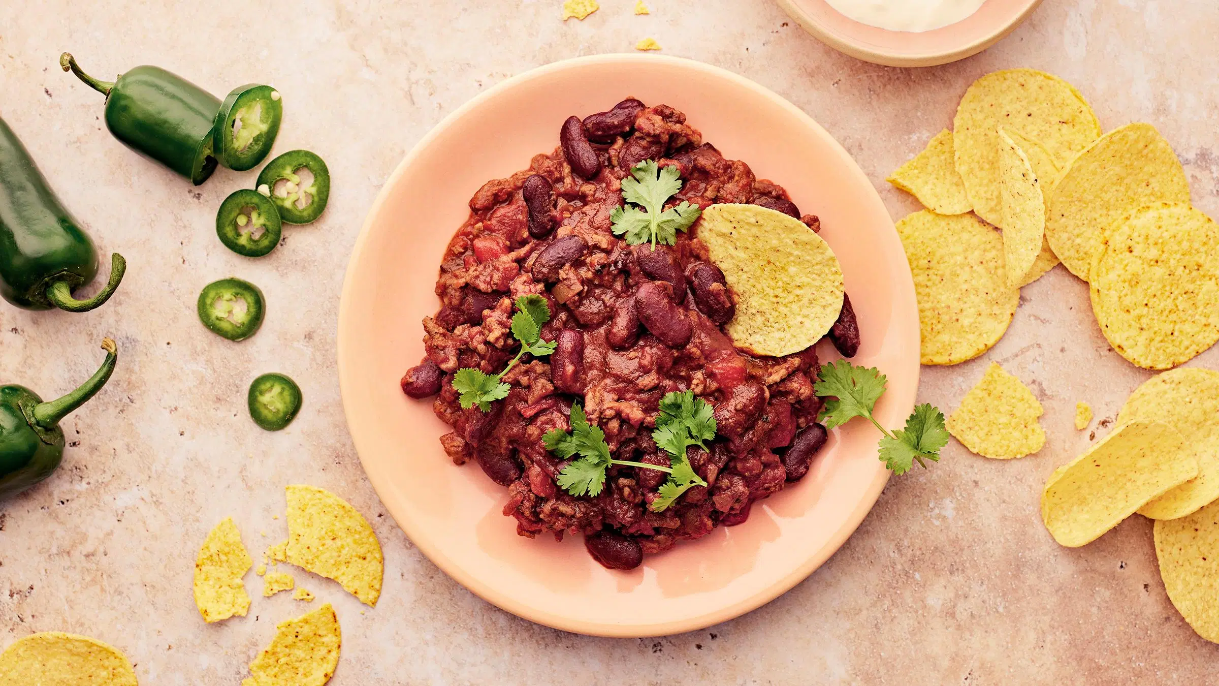Lautasellinen chili con carnea ja nachoja.