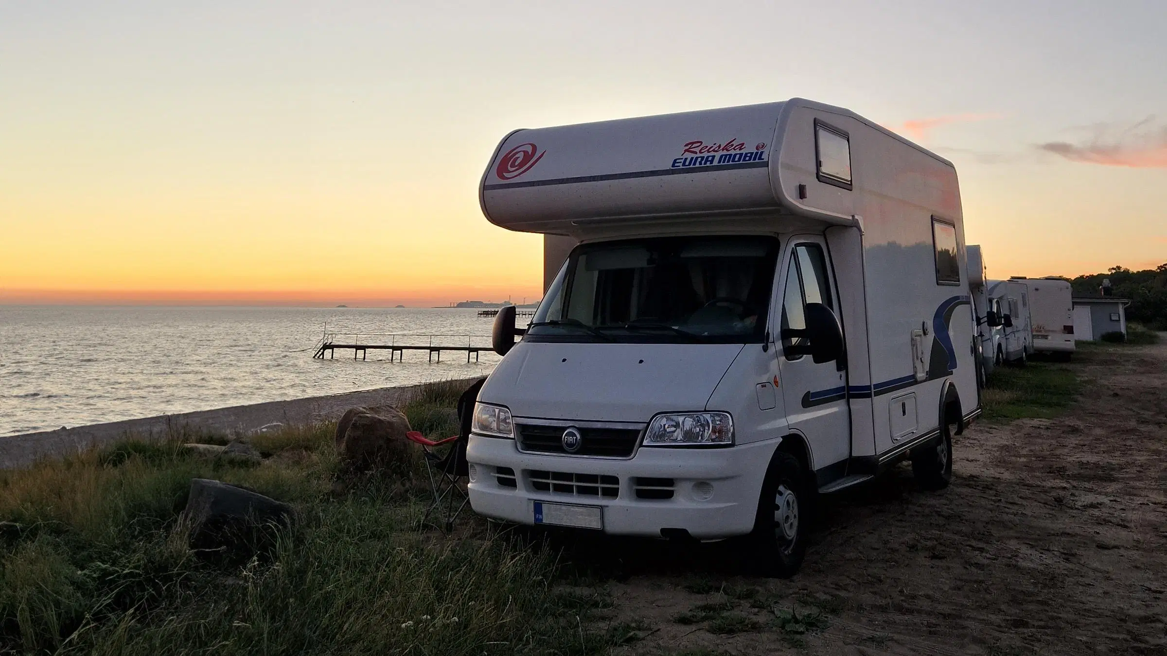 Kuvassa matkailuauto veden äärellä.