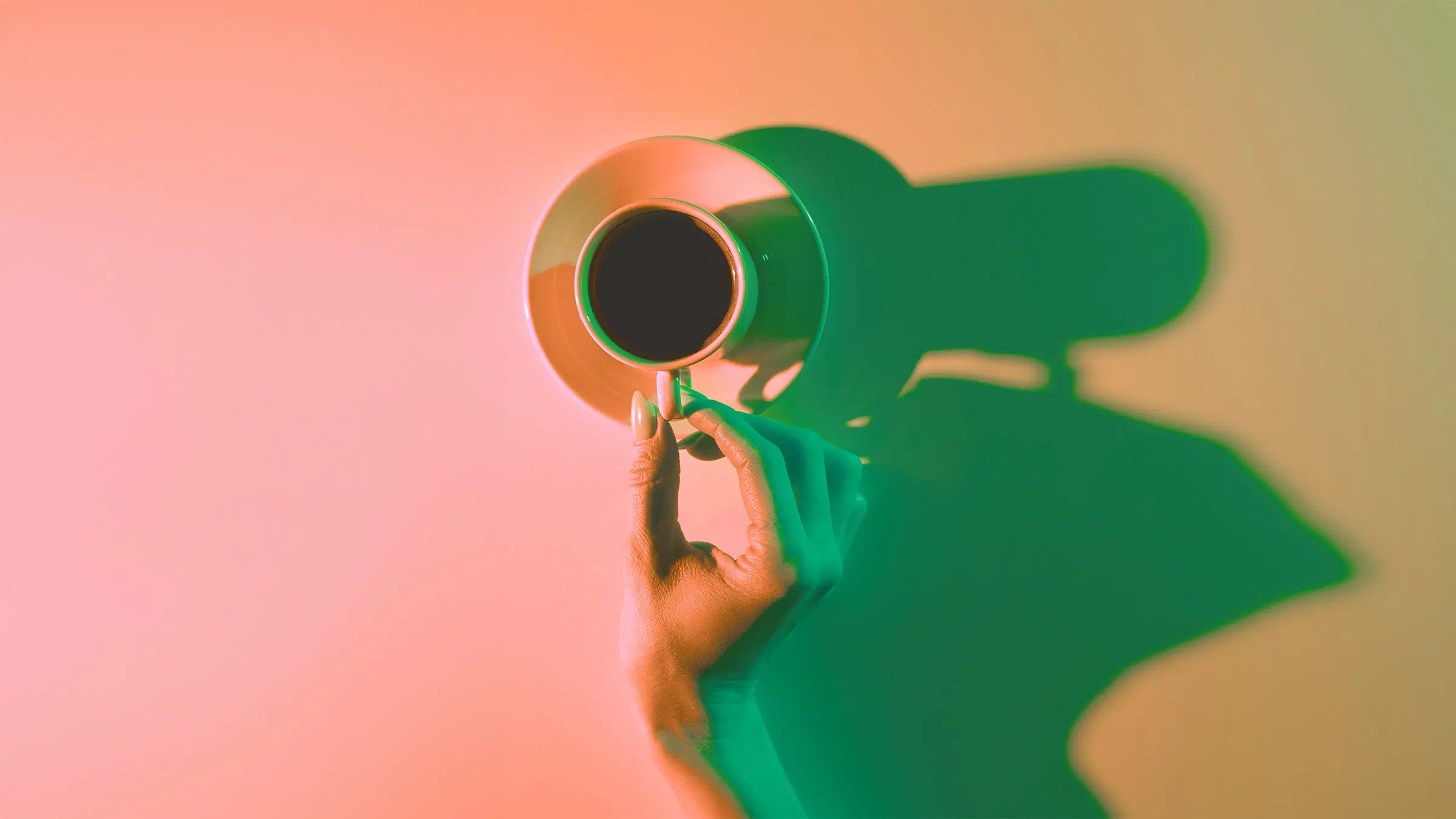 Käsi, jossa on kahvikuppi.