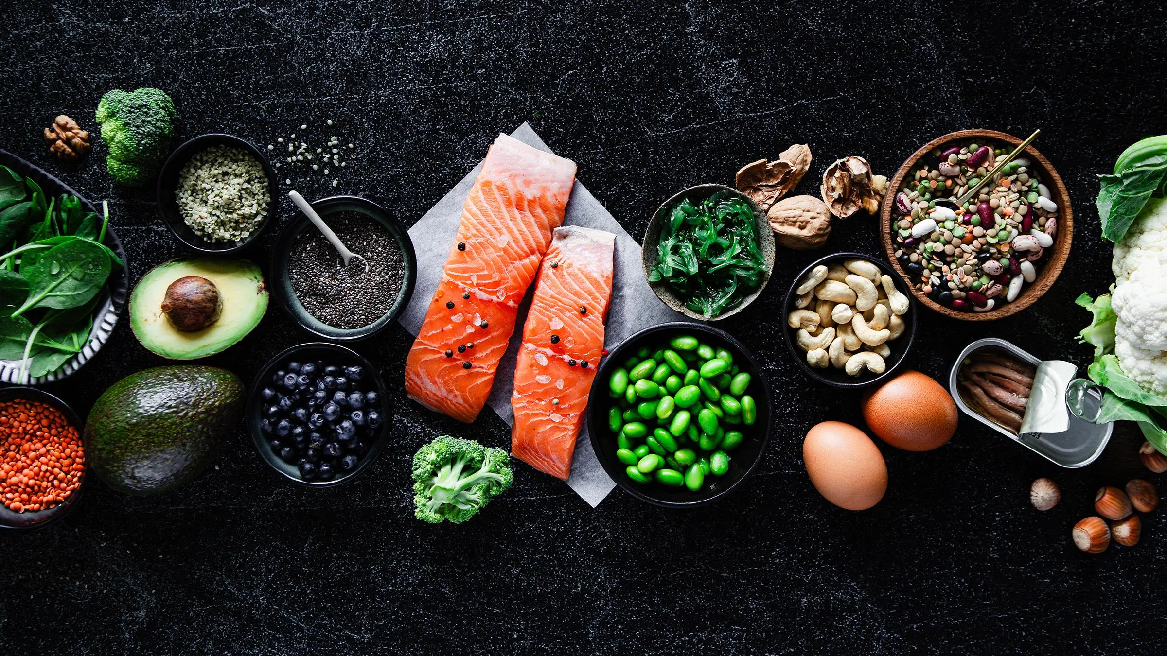 Keto ruokavalioon sopivaa ruokaa: lohta, edamepapuja, pähkinöitä, kananmunaa, avokadoa.