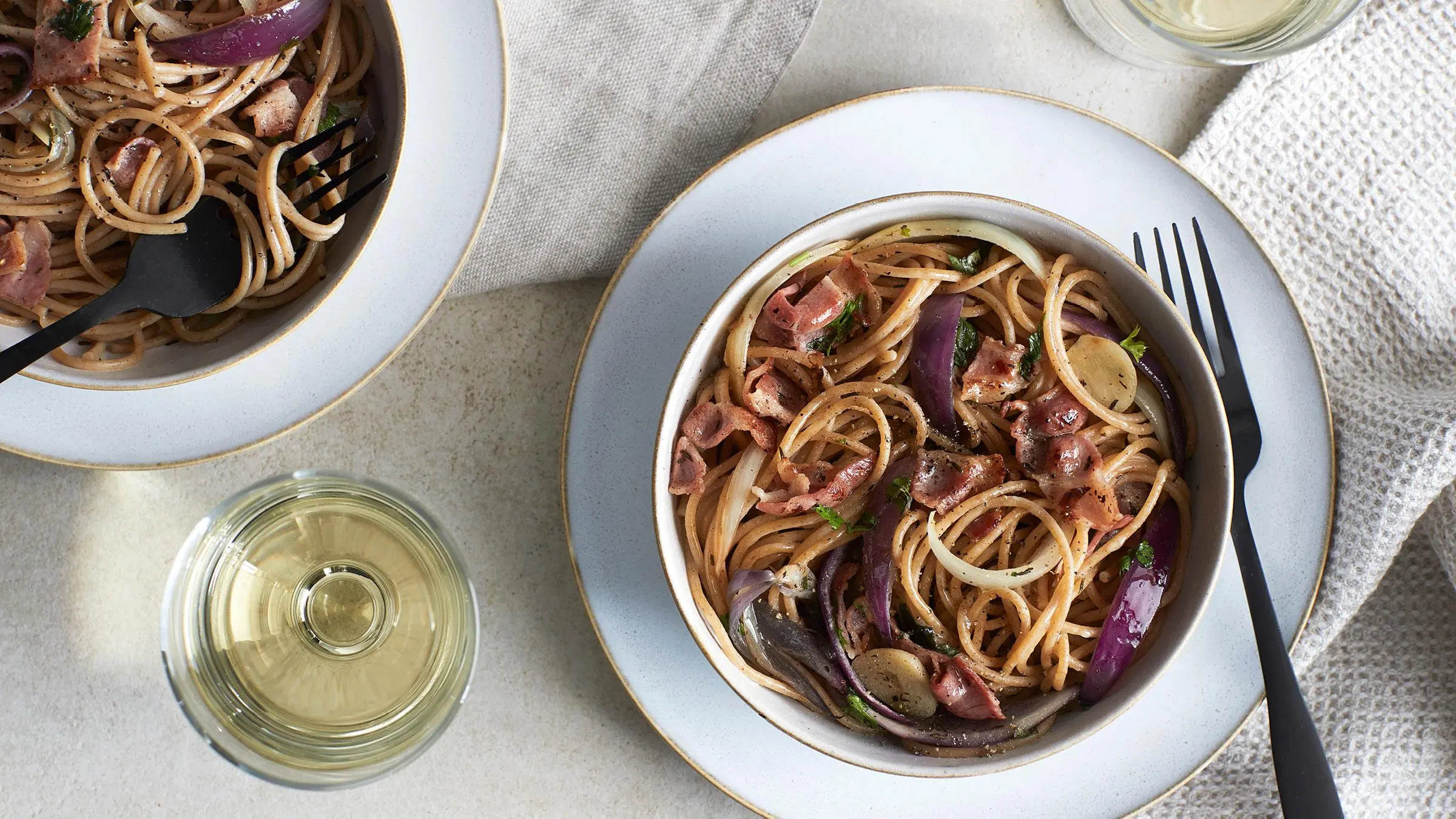 Kaksi annosta sipuli-pekonipastaa.