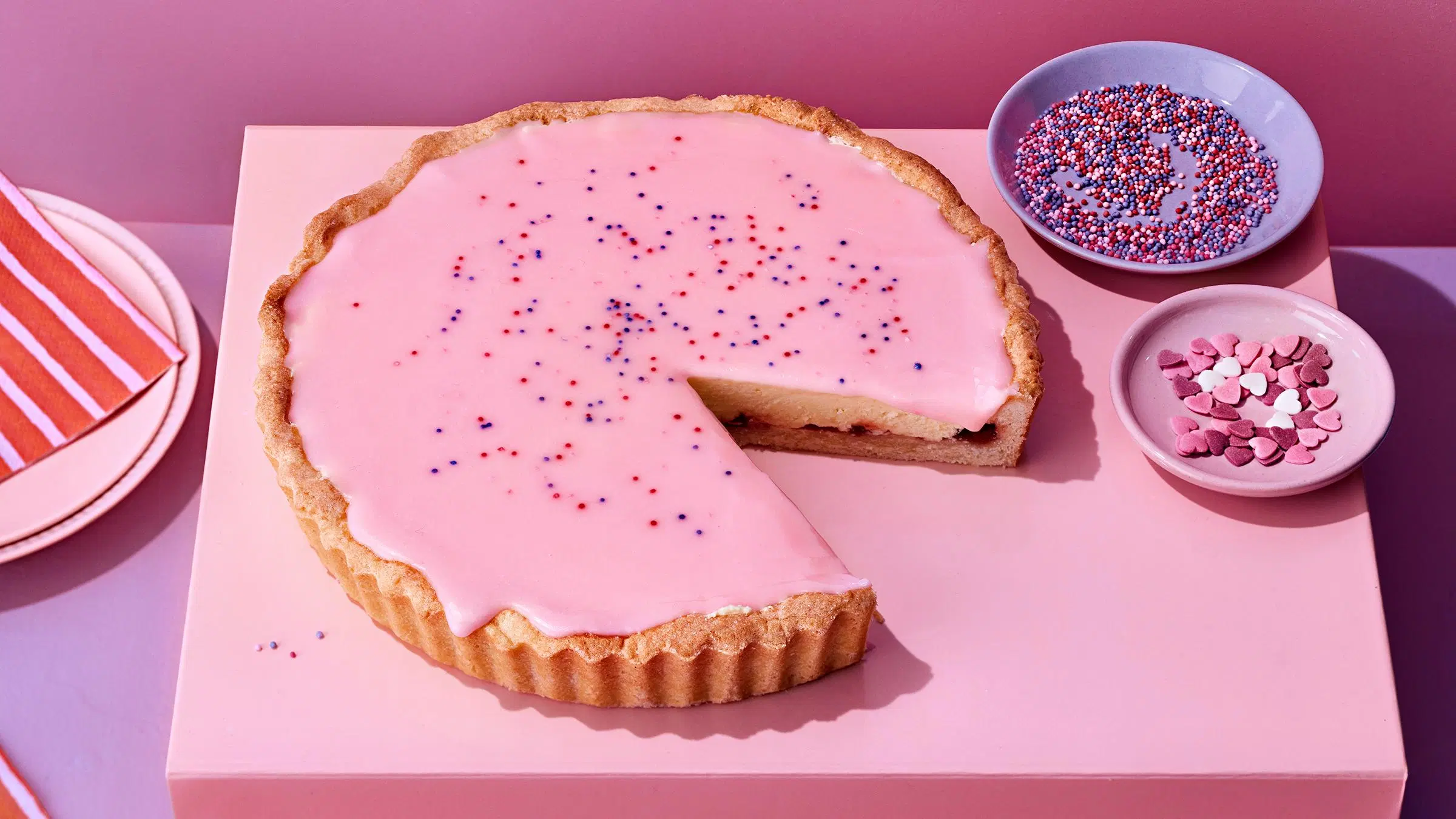 Iso vaaleanpunainen bebepiirakka pöydällä.