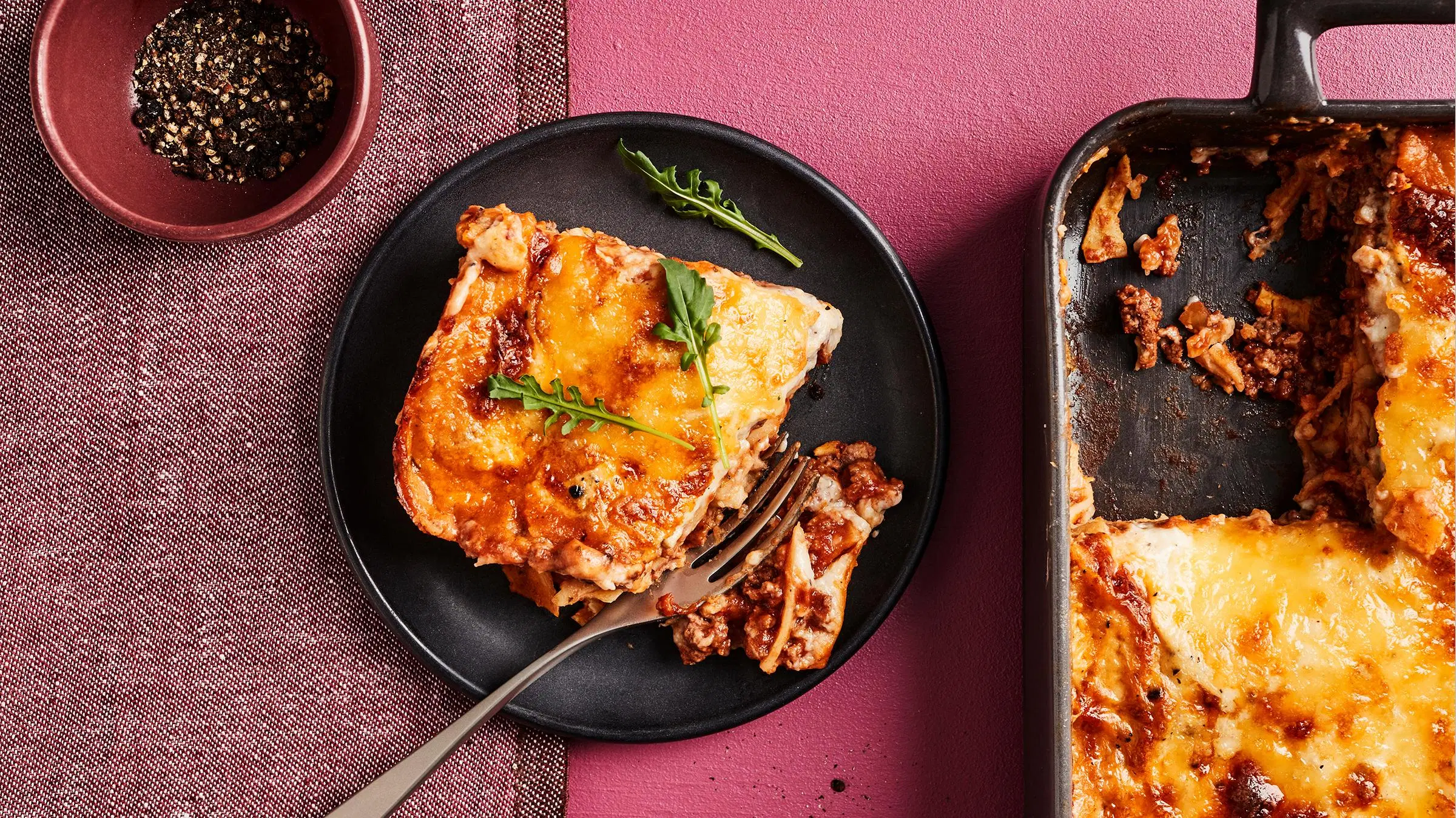 Pippurista lasagnea lautasella ja uunivuoassa.