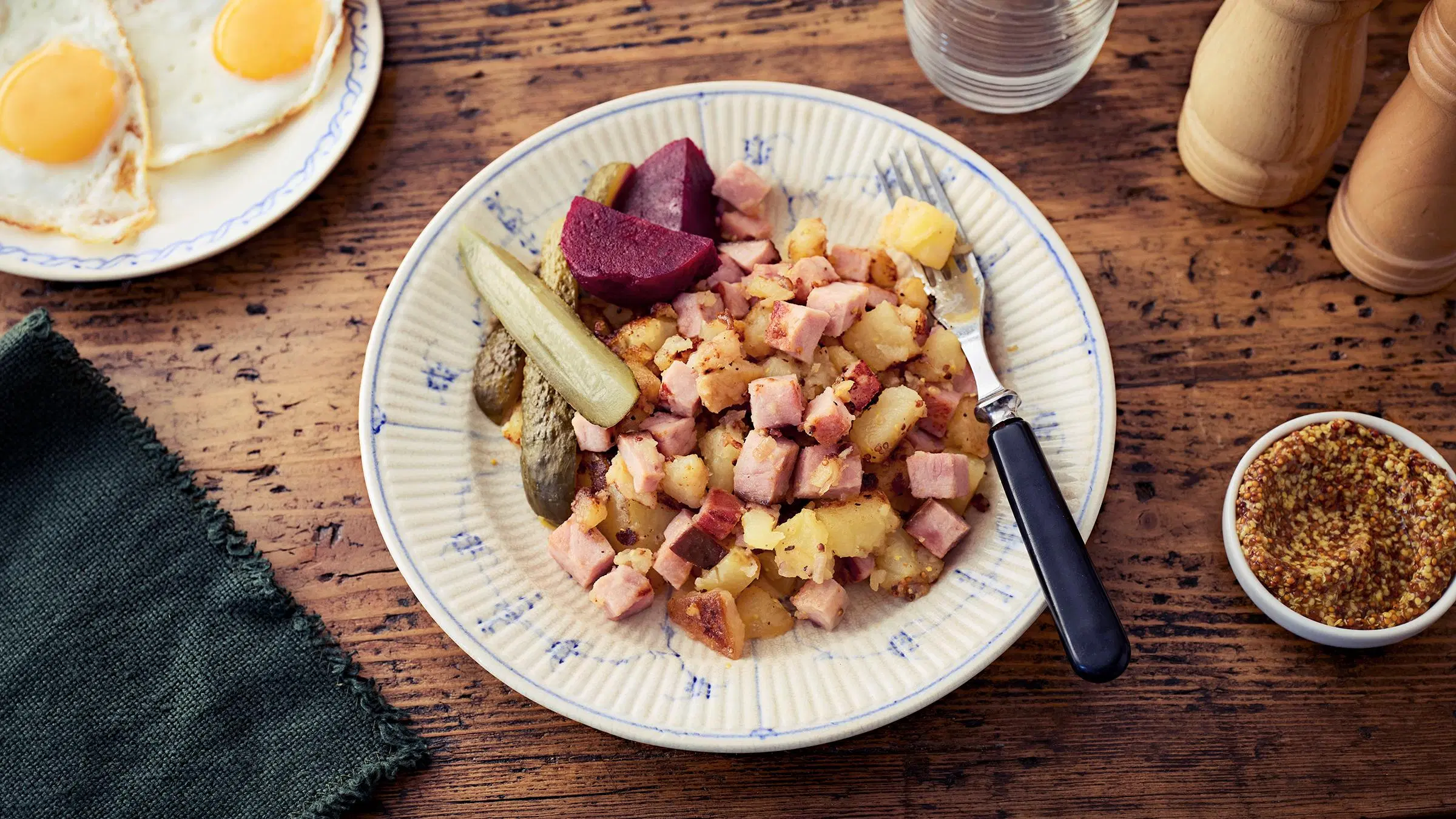 Joulukinkusta tehtyä pyttipannua lautasella, jossa myös säilykepunajuuria ja maustekurkkuja.