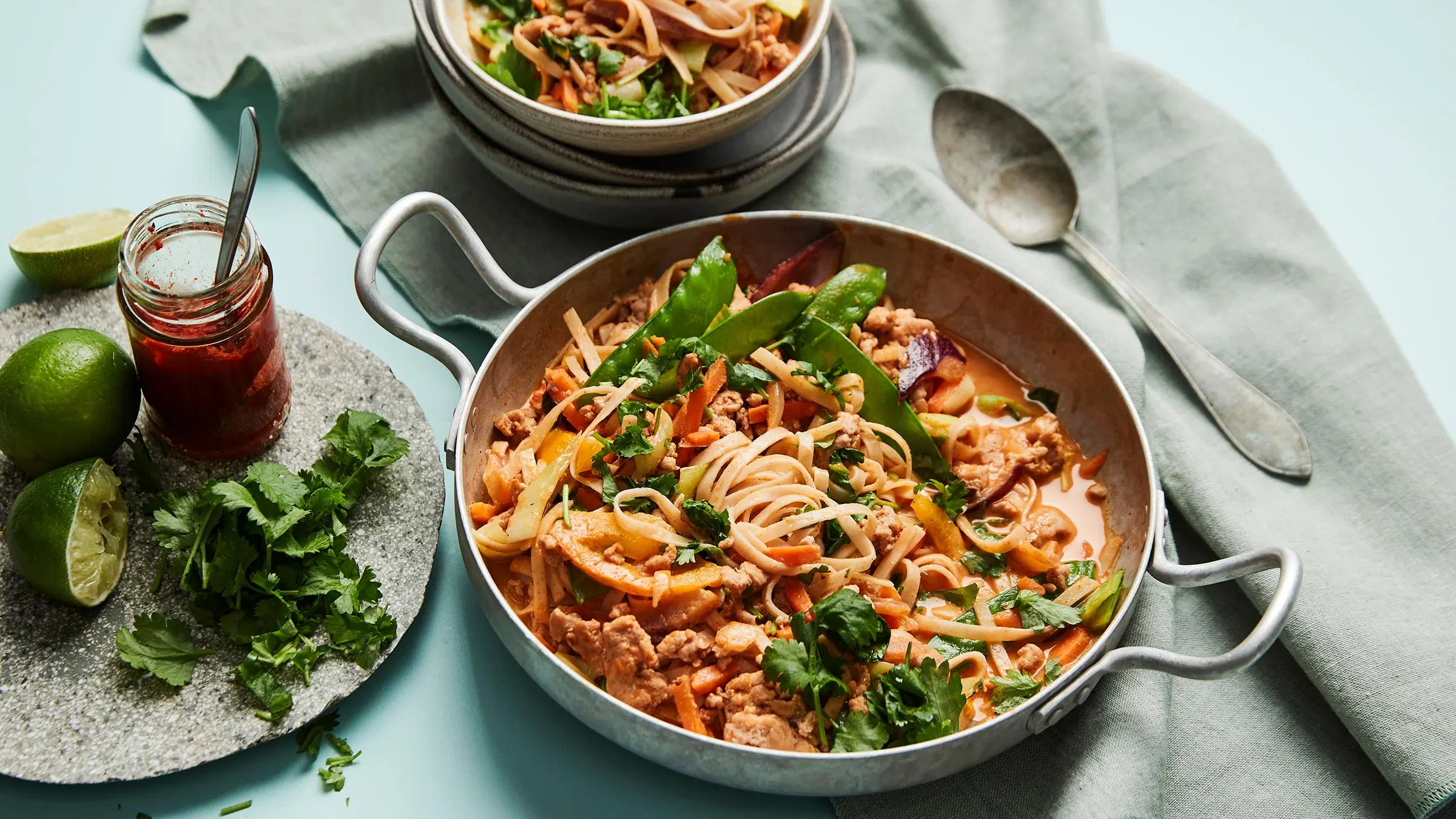 Nopeaa thai-broileriwokkia tarjoiluastiassa ja kulhossa.