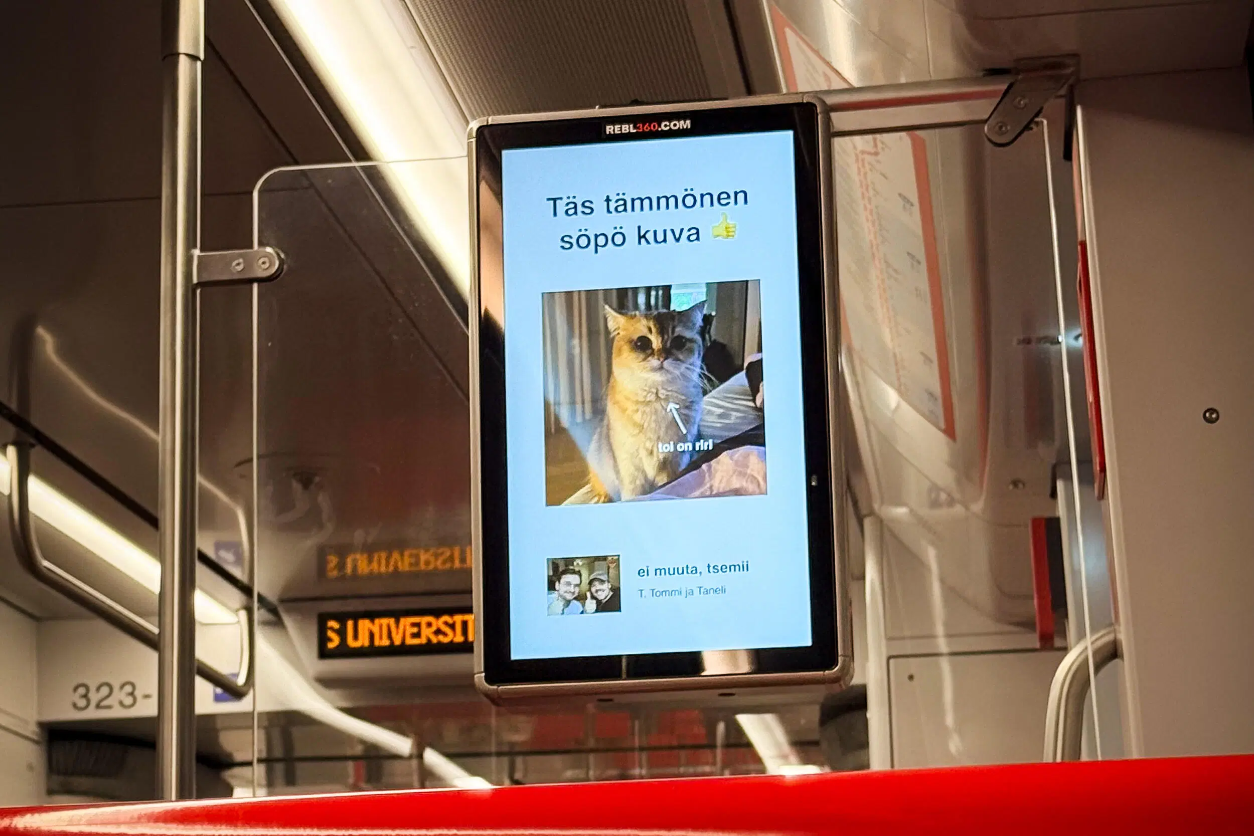 Kaksi miestä näyttävät peukkua. Taustalla kuvat metron ilmoitustauluista.