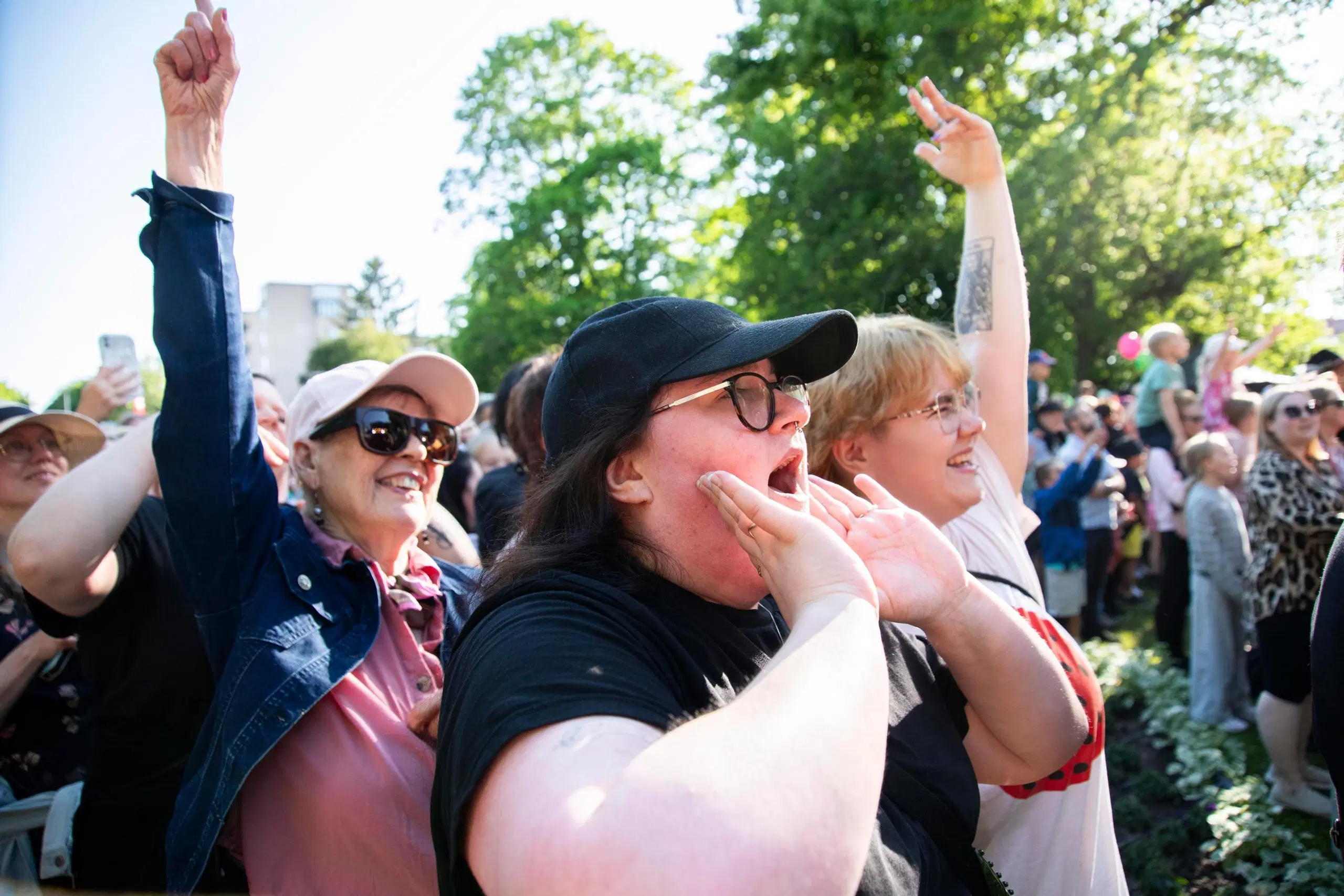 Kolme naista hurraa yleisössä.