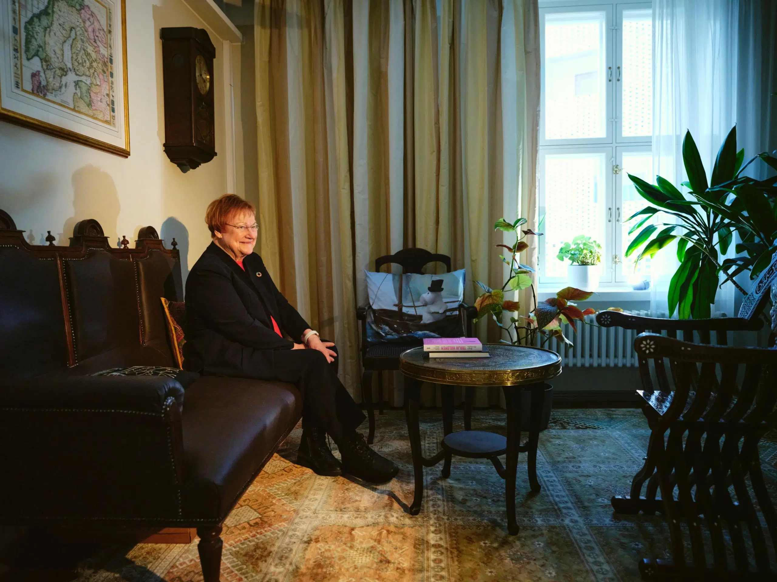 Tarja Halonen istuu tummalla antiikkisohvalla.