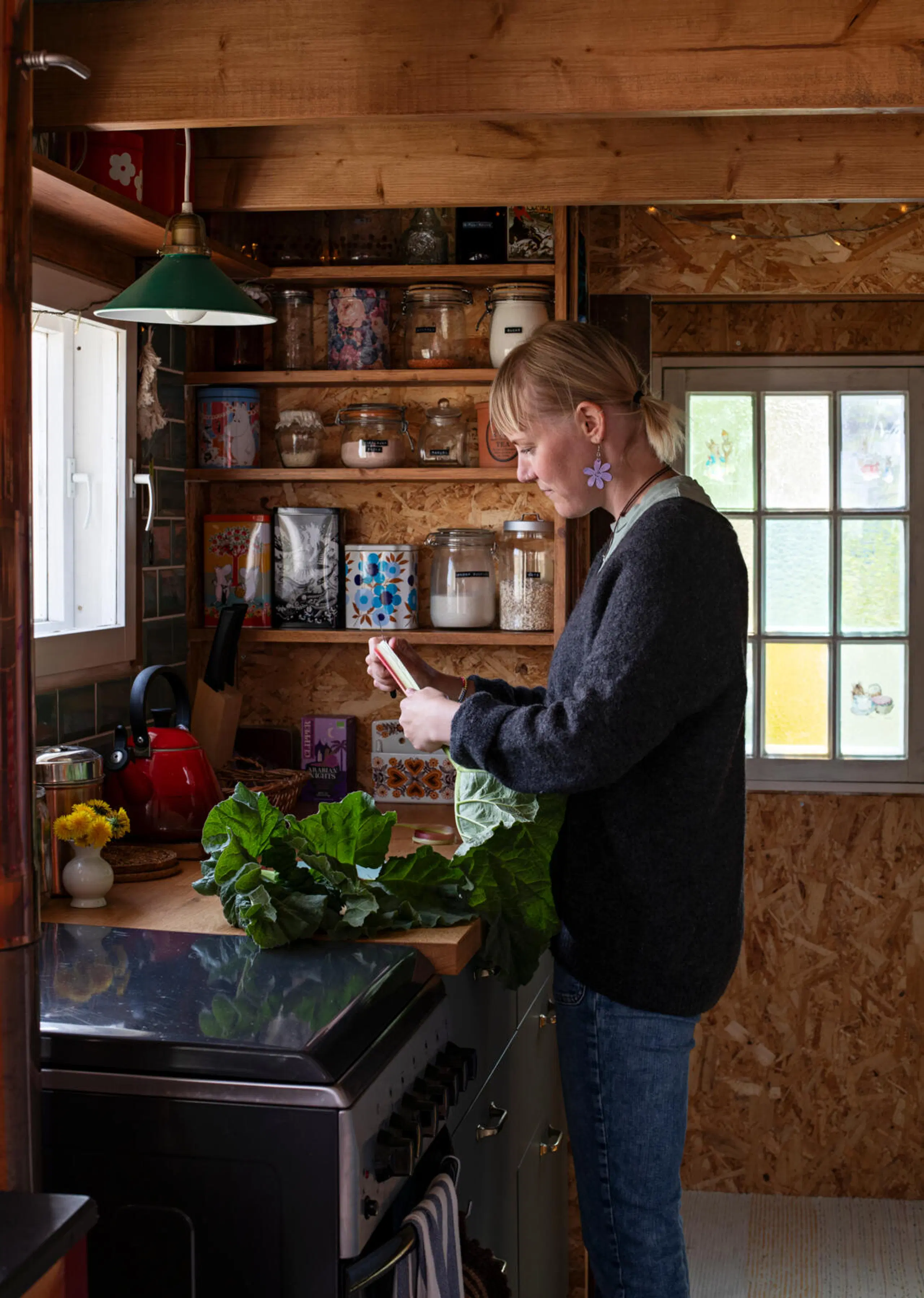 Tiia käsittelee raparperia minitalon keittiössä.