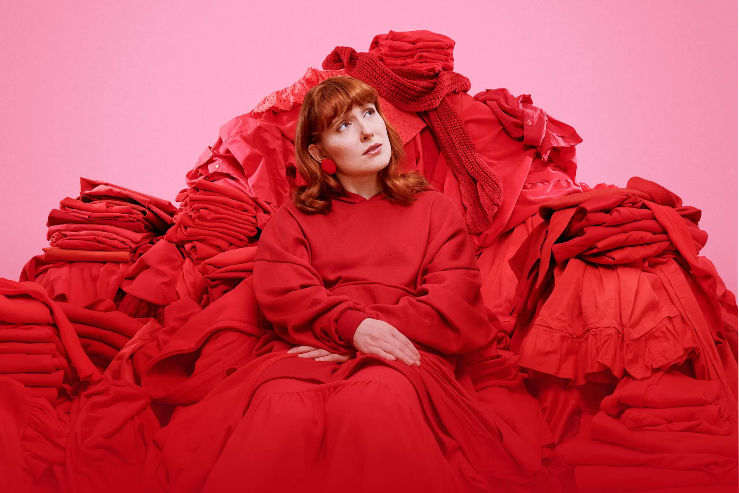 Nainen istuu punaisessa vaatekasassa