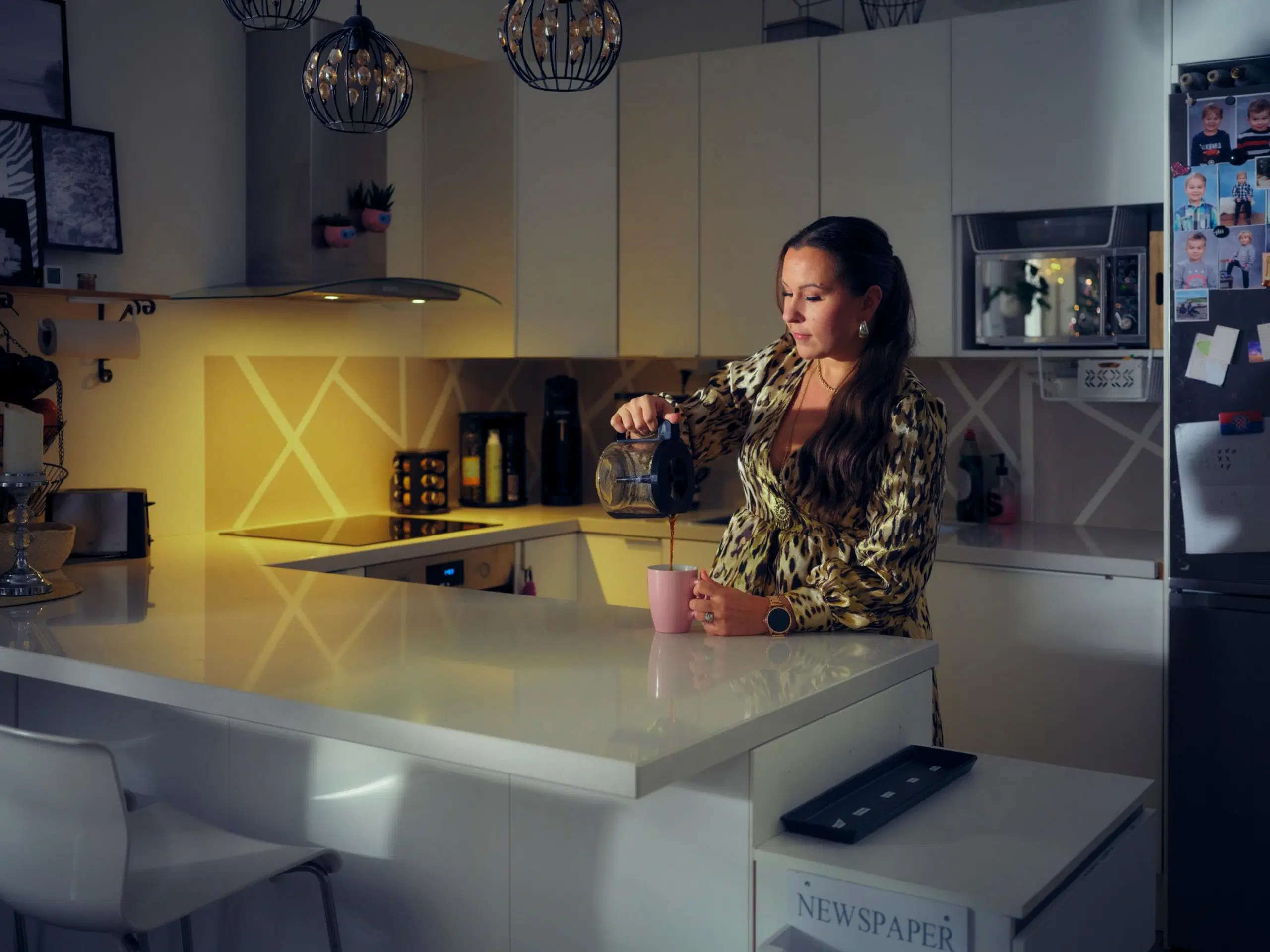 Pauliina Lappeteläinen kaataa kahvia vaaleanpunaiseen kahvikuppiin vaaleassa keittiössä