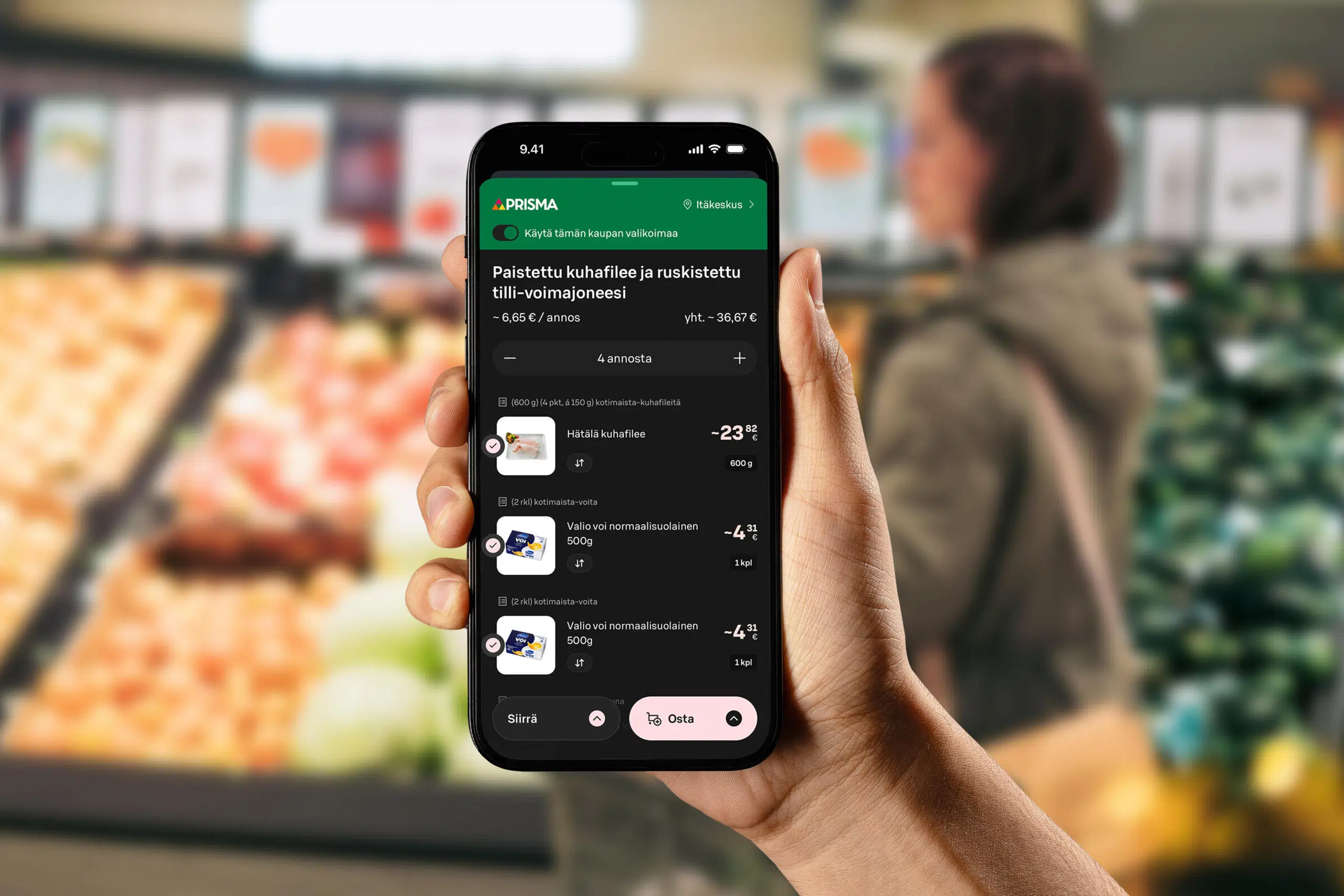 Käsi pitelee puhelinta kaupassa, näytöllä on Yhteishyvä Ruoka -sovelluksen reseptin ostoslistanäkymä.