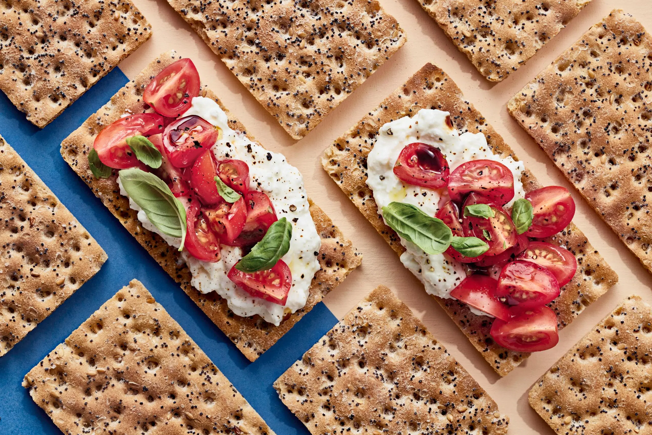 Näkkileipä raejuustolla ja tomaateilla.