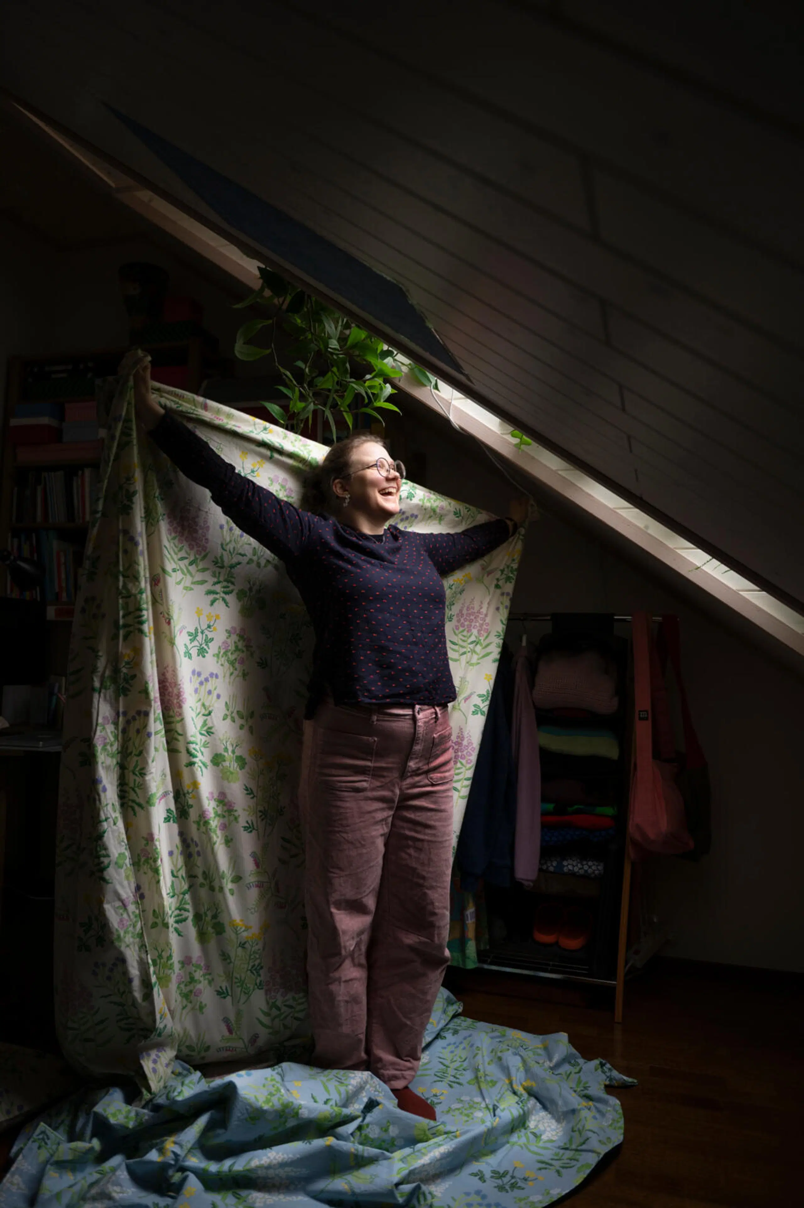 Hanna Forsman pitelee kukallista Joutomaa-lakanaa päänsä yläpuolella.