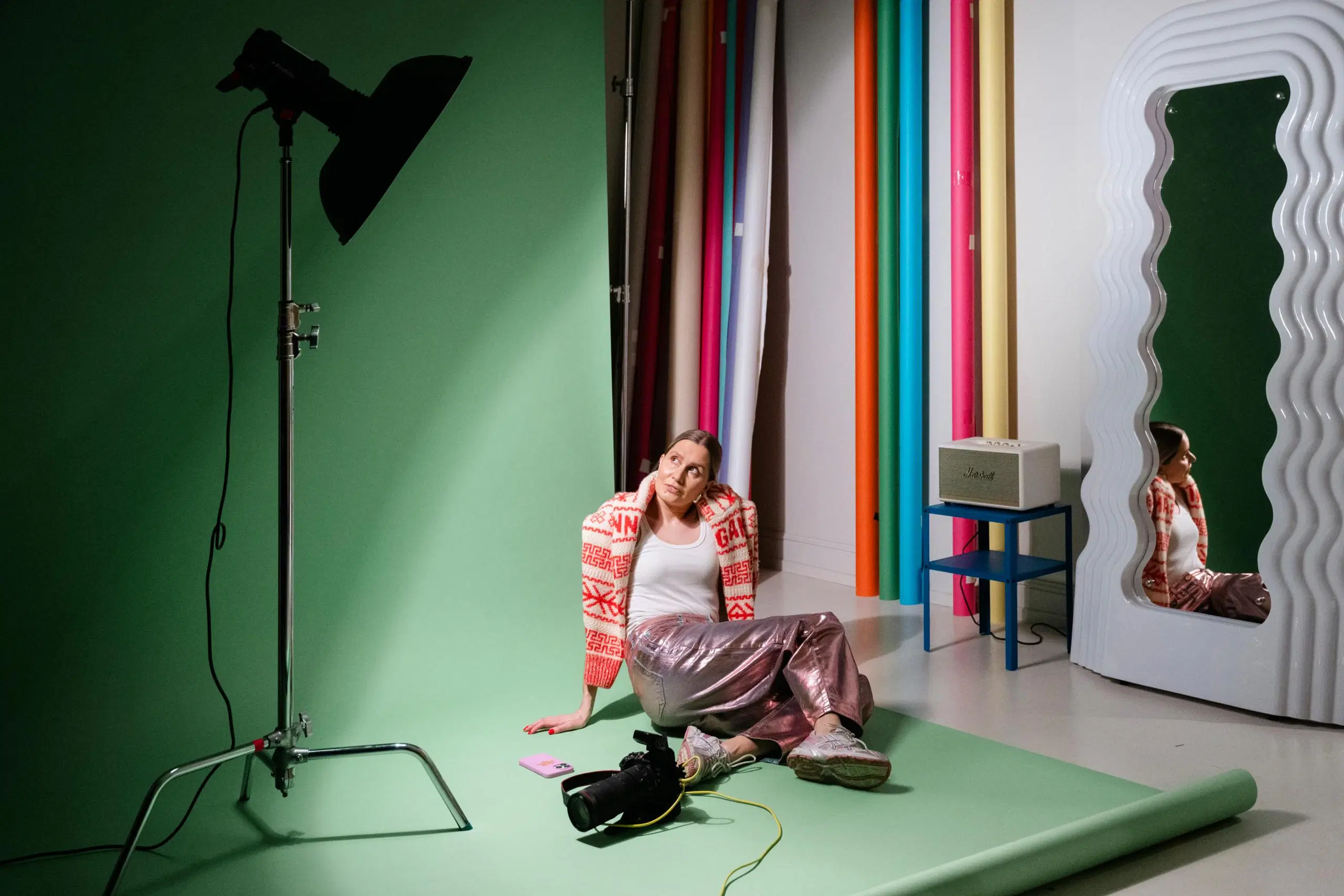 Janita Autio istuu valokuvausstudionsa lattialla.
