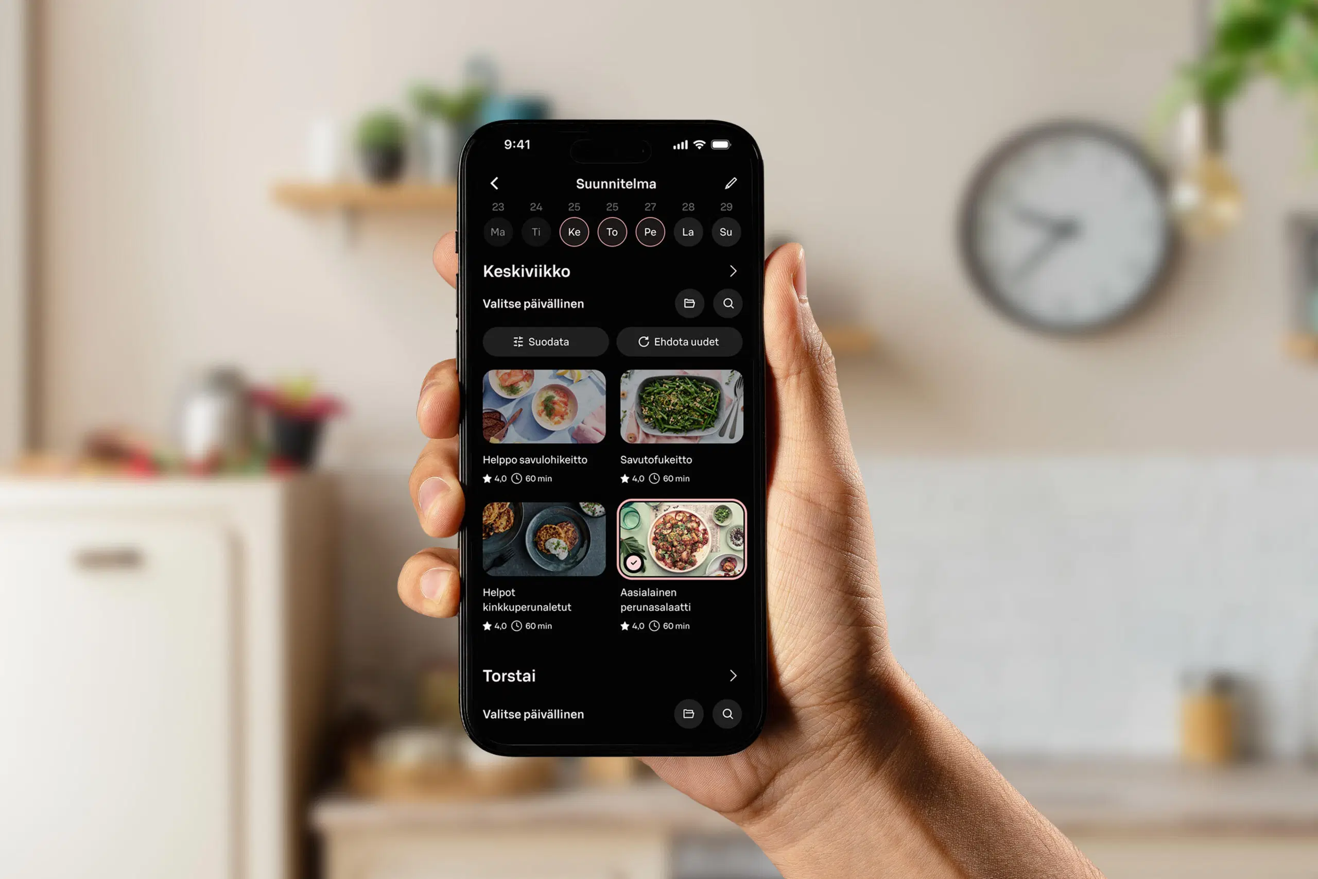 Käsi pitelee puhelinta, jossa on auki Yhteishyvä Ruoka -sovelluksen suunnittelutyökalu.