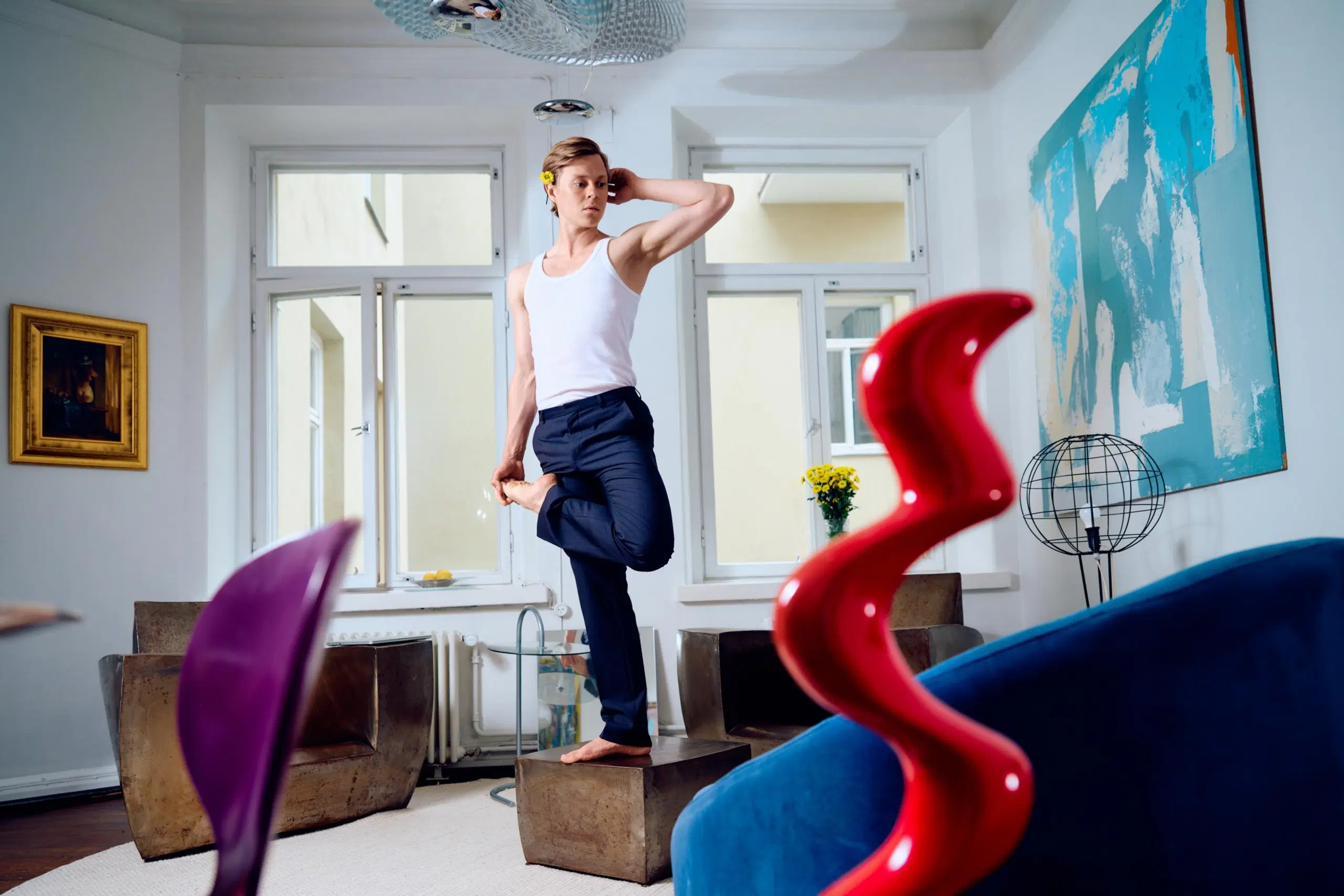 Atte Kilpinen venyttelee seisten rautaisen sohvapöydän päällä.