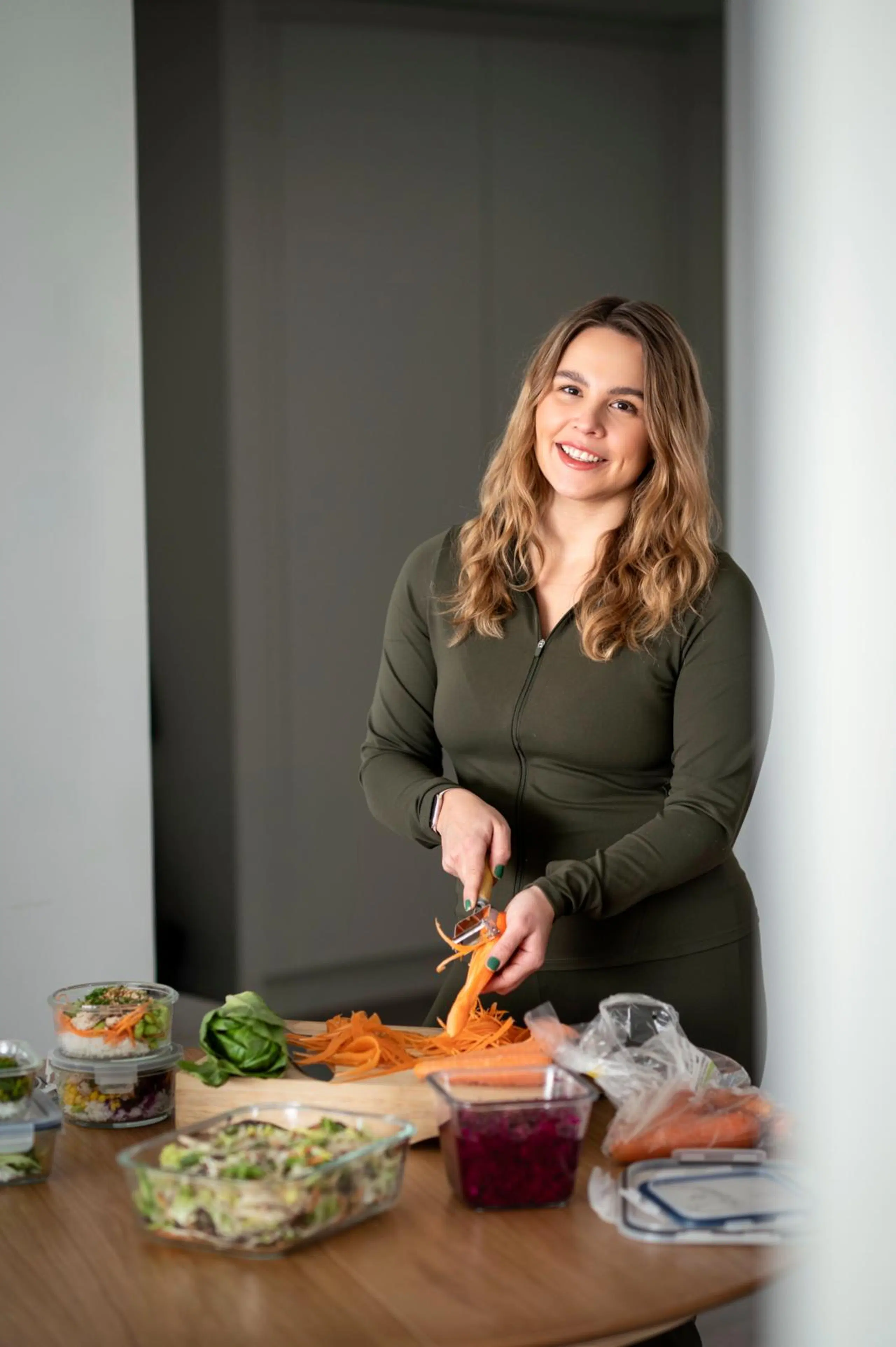 Eveliina Uosukainen kuorii porkkanaa keittiössä.