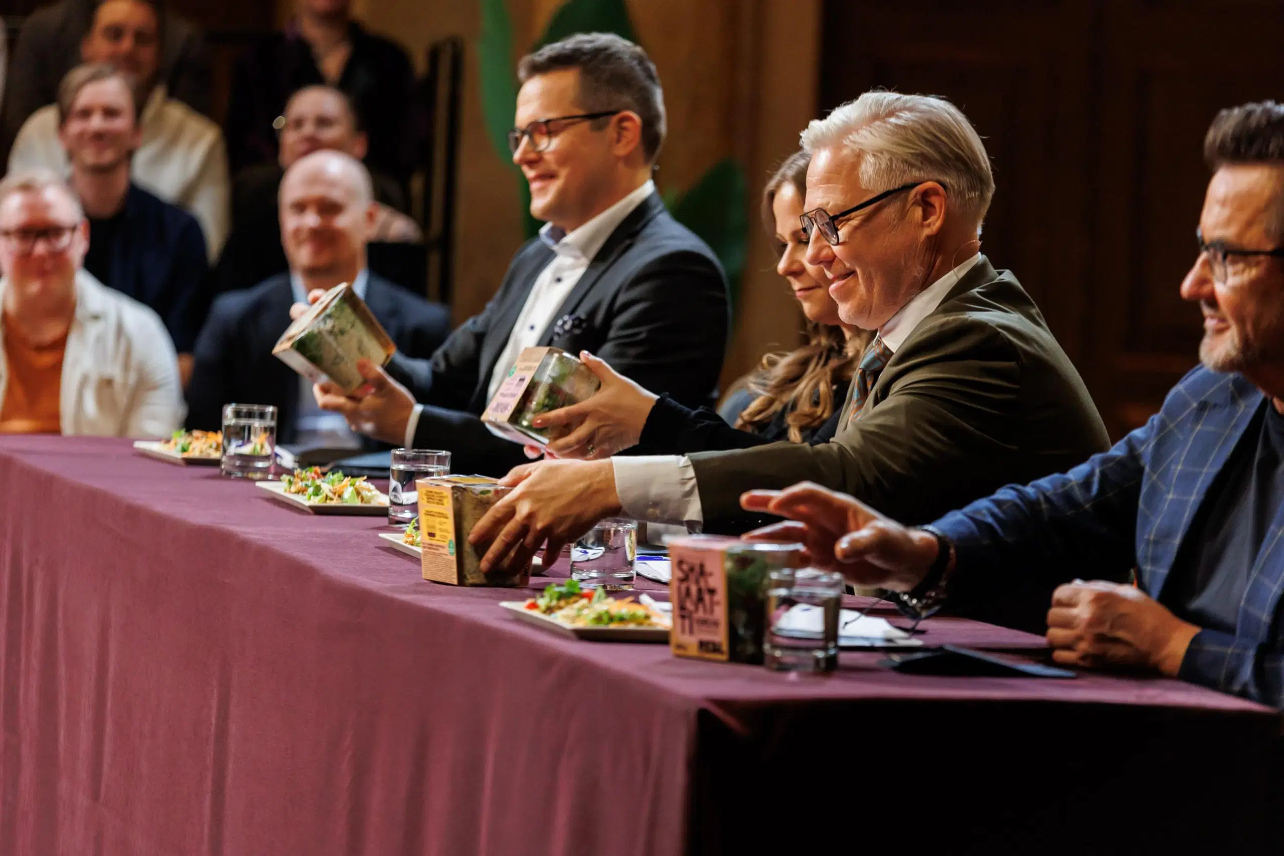 Tuomaristo istuu pöydän takana ja hypistelee Elinan Shalaatin pakkausta.