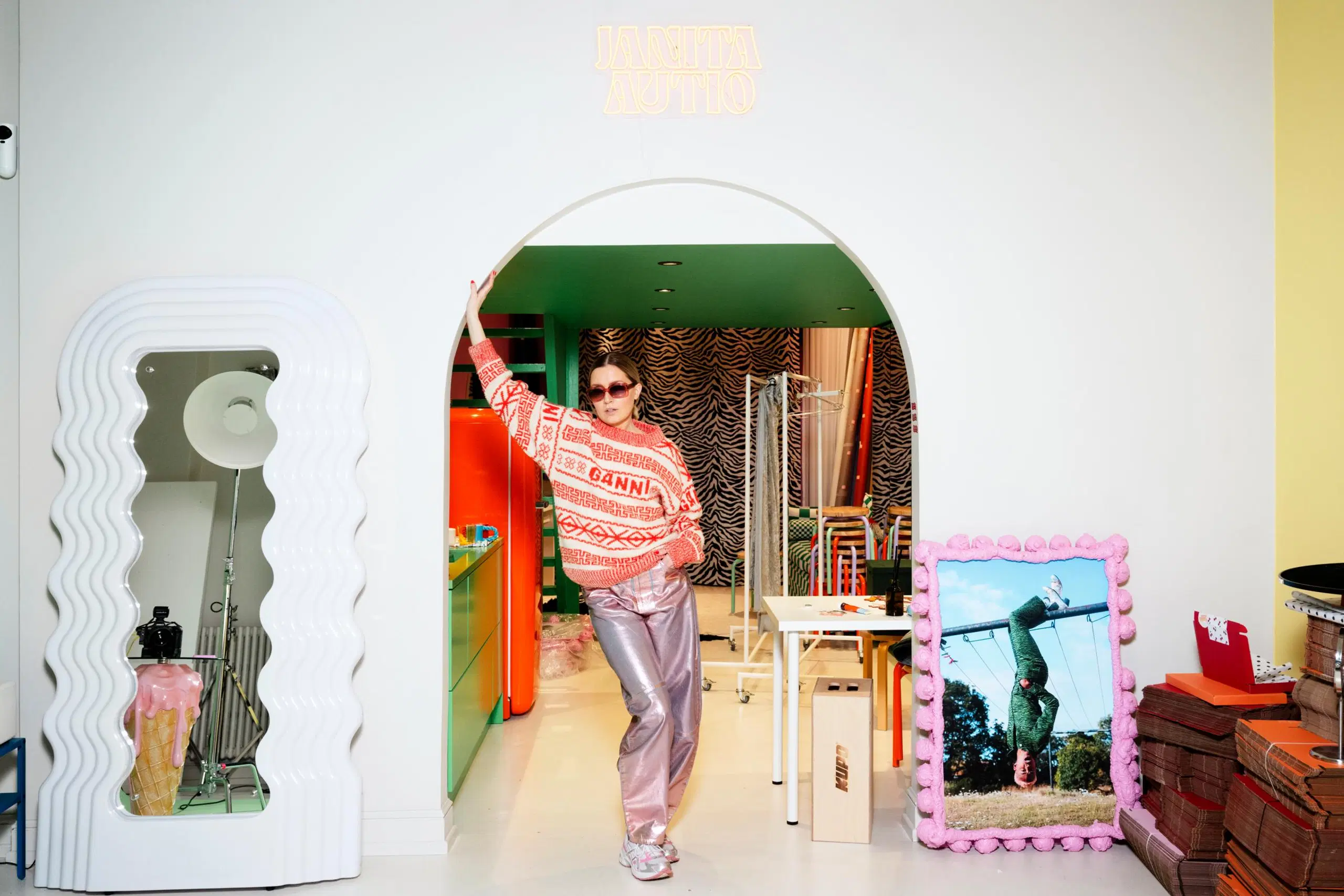 Janita Autio nojailee työhuoneensa oviaukkoon.