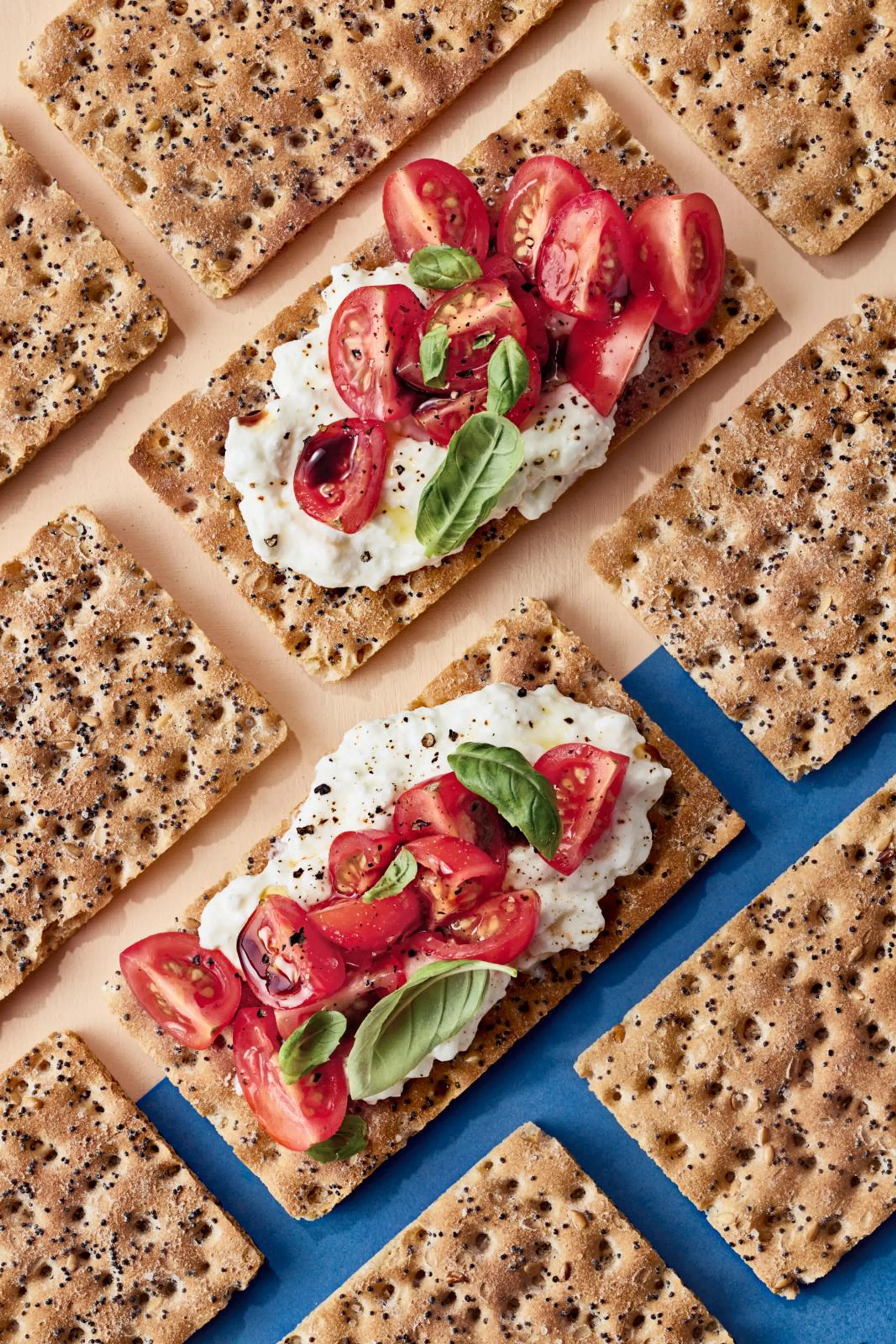 Näkkileipä raejuustolla ja tomaateilla.