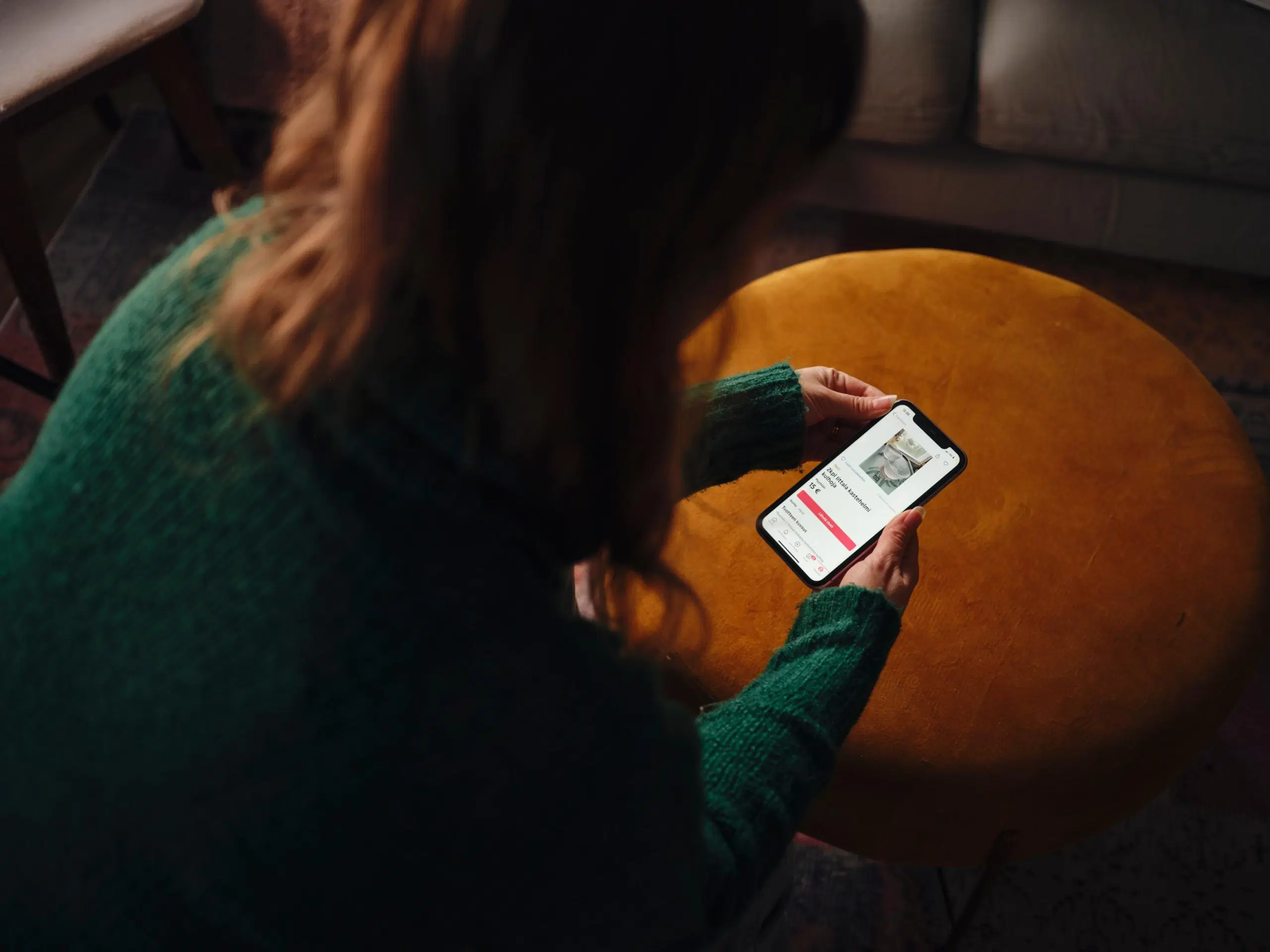 Natasa Höök pitelee puhelinta, jossa on auki kirpputorisovellus.