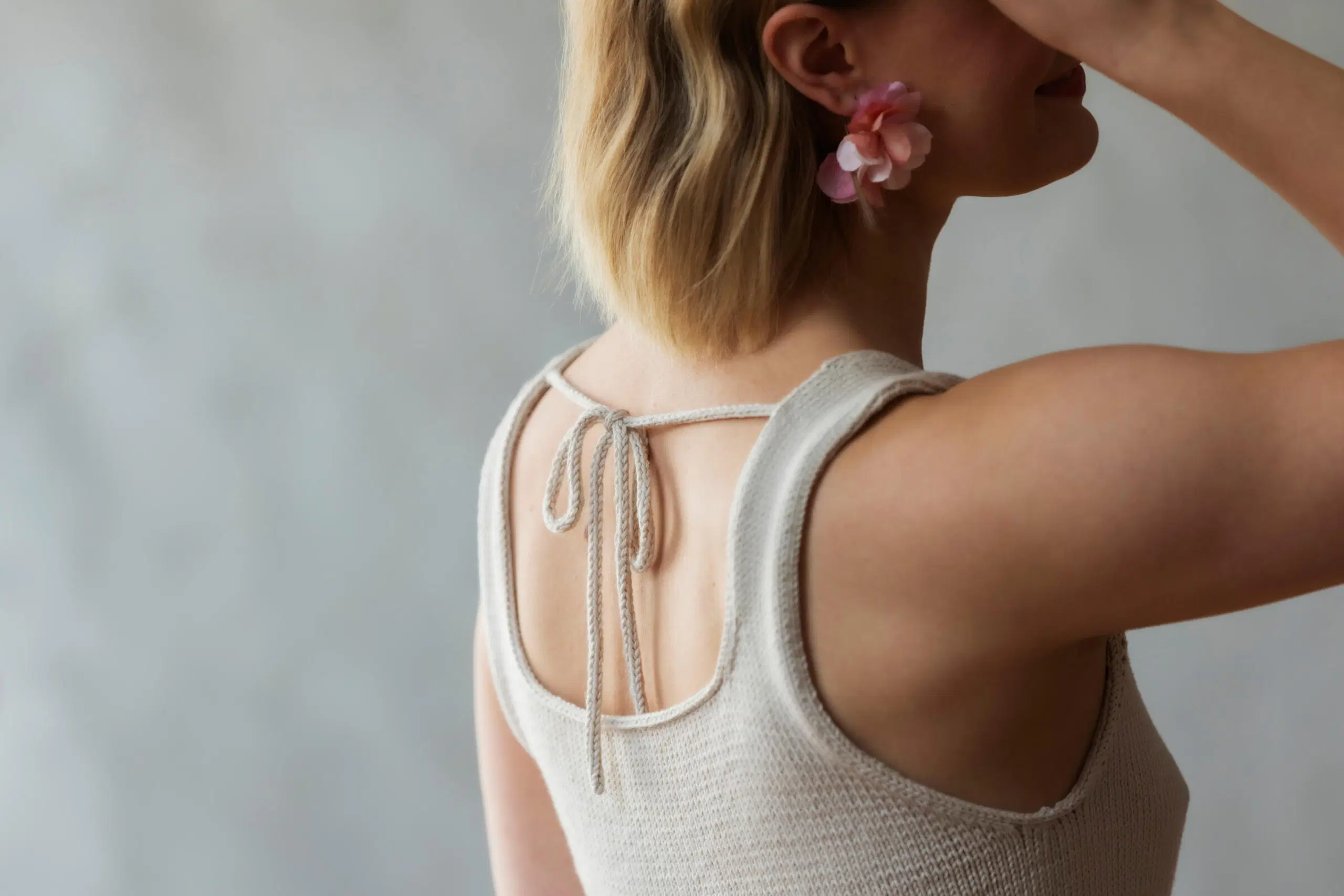 Lily-neuletoppi selkäpuolelta, yksityiskohtana kaunis nyörinauhasta solmittu rusetti 