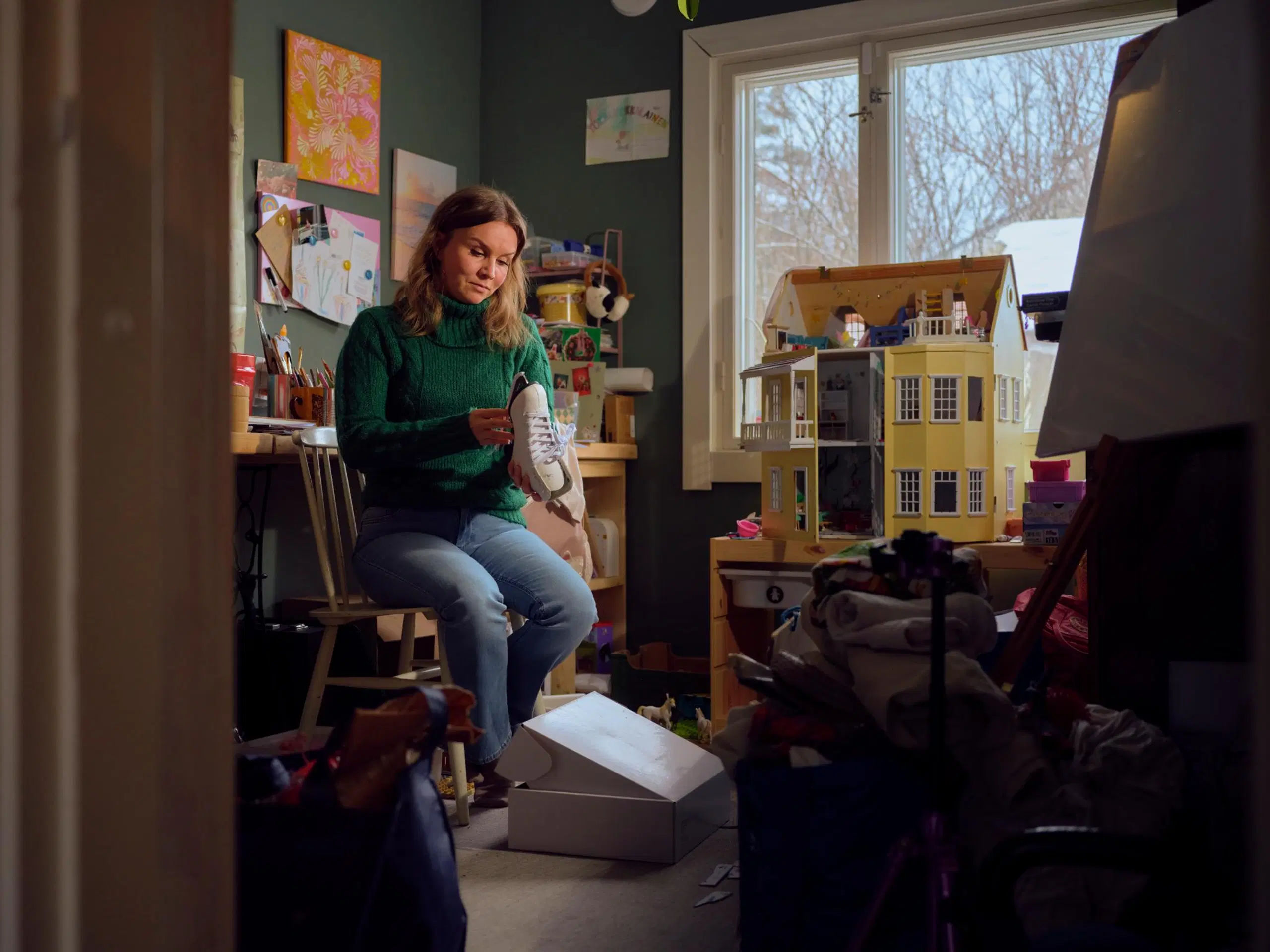 Natasa istuu lastenhuoneessa ja pitää kaunoluistinta kädessään.