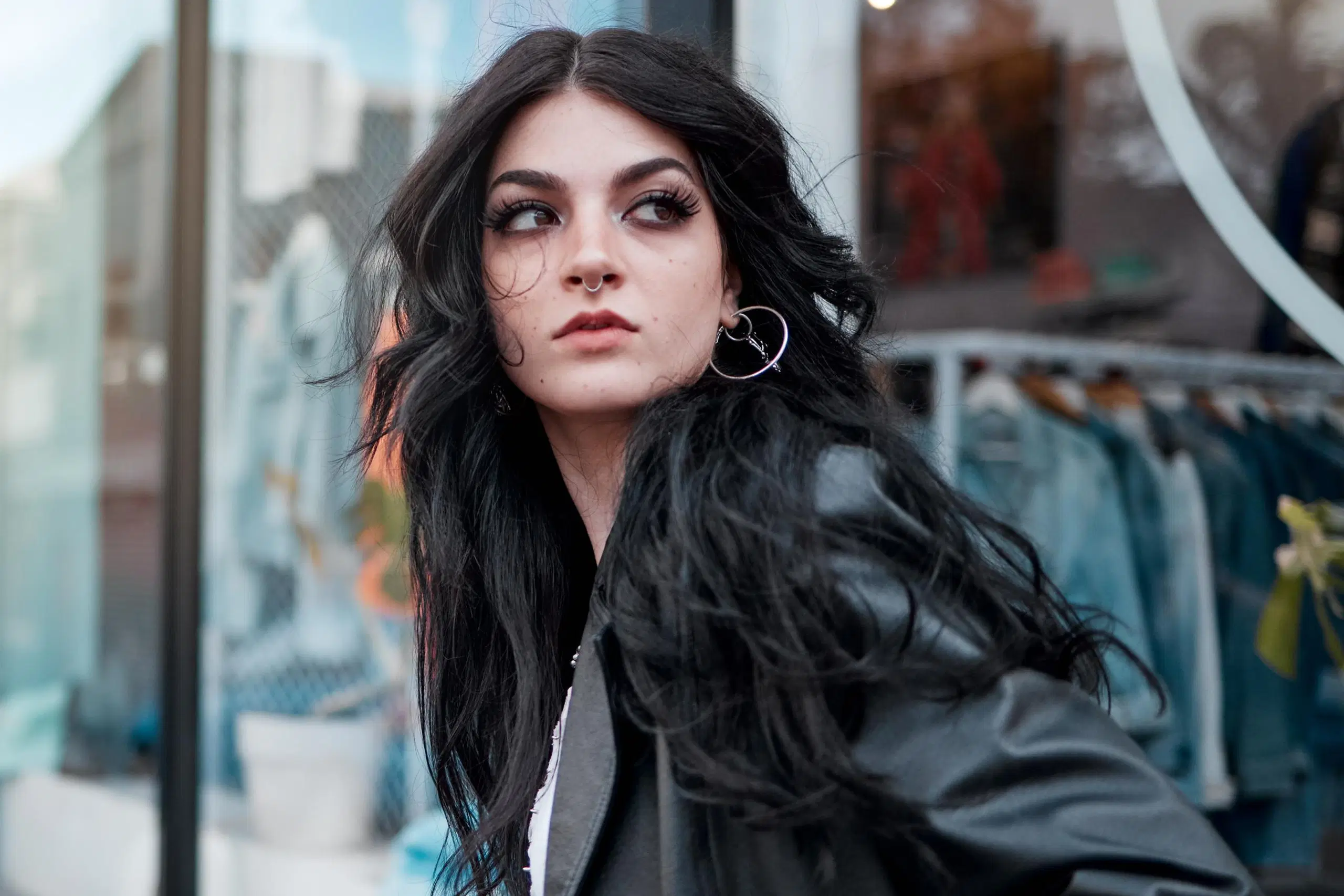 Mustahiuksinen nuori nainen vahvassa meikissä