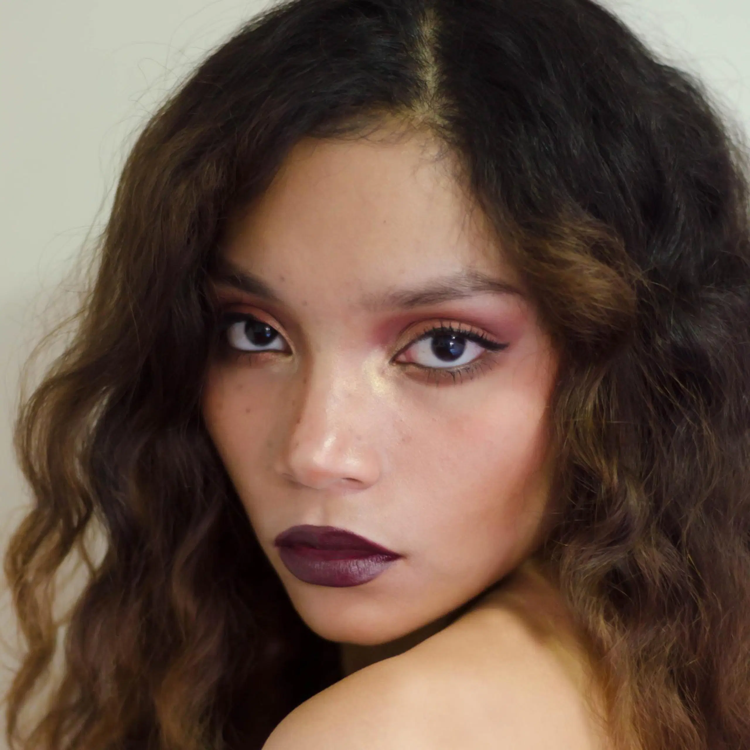 Nuori nainen, jolla on luumun sävyinen meikki.