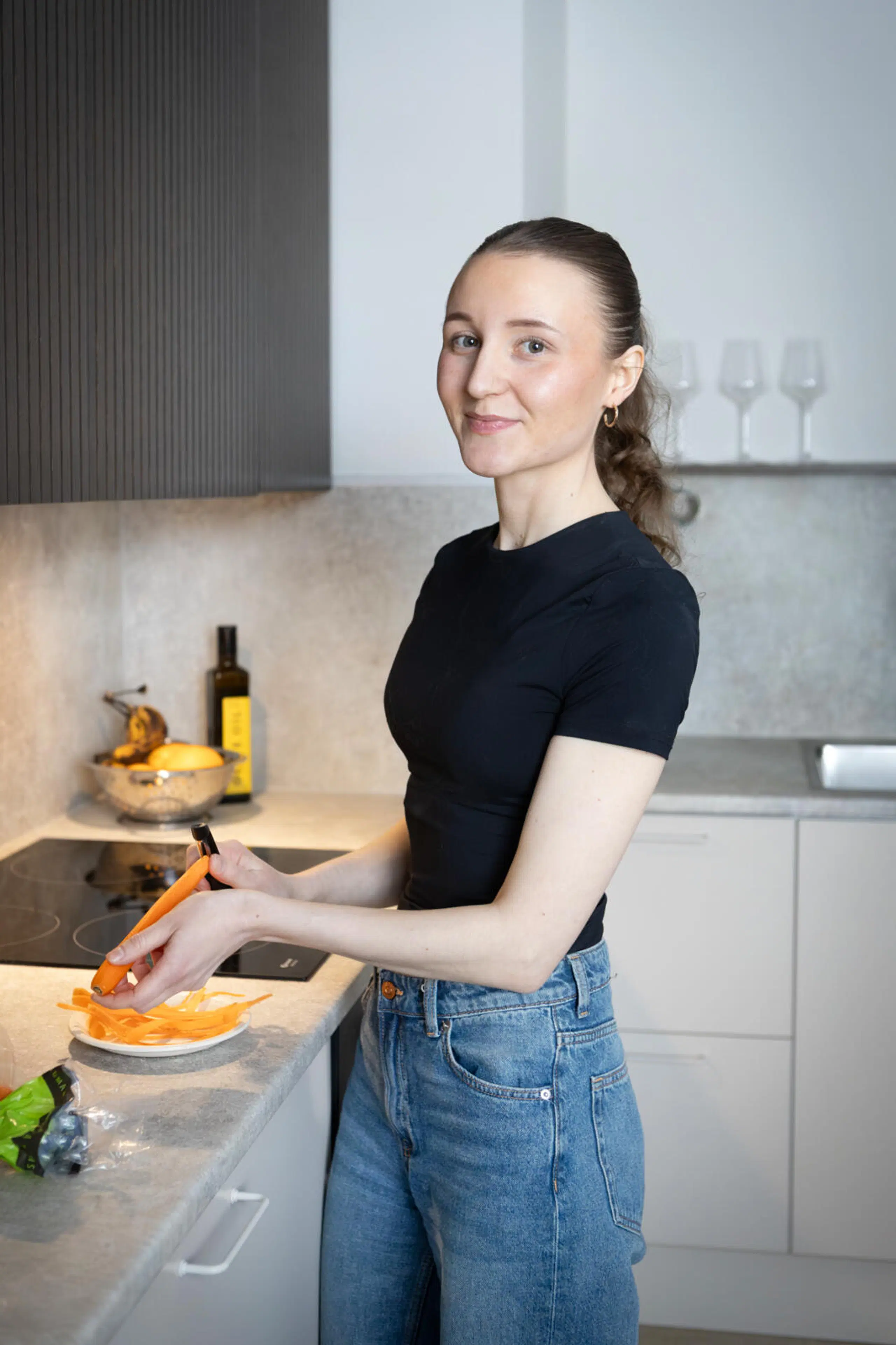 Ina Mattila kuorii keittiössä porkkanaa.