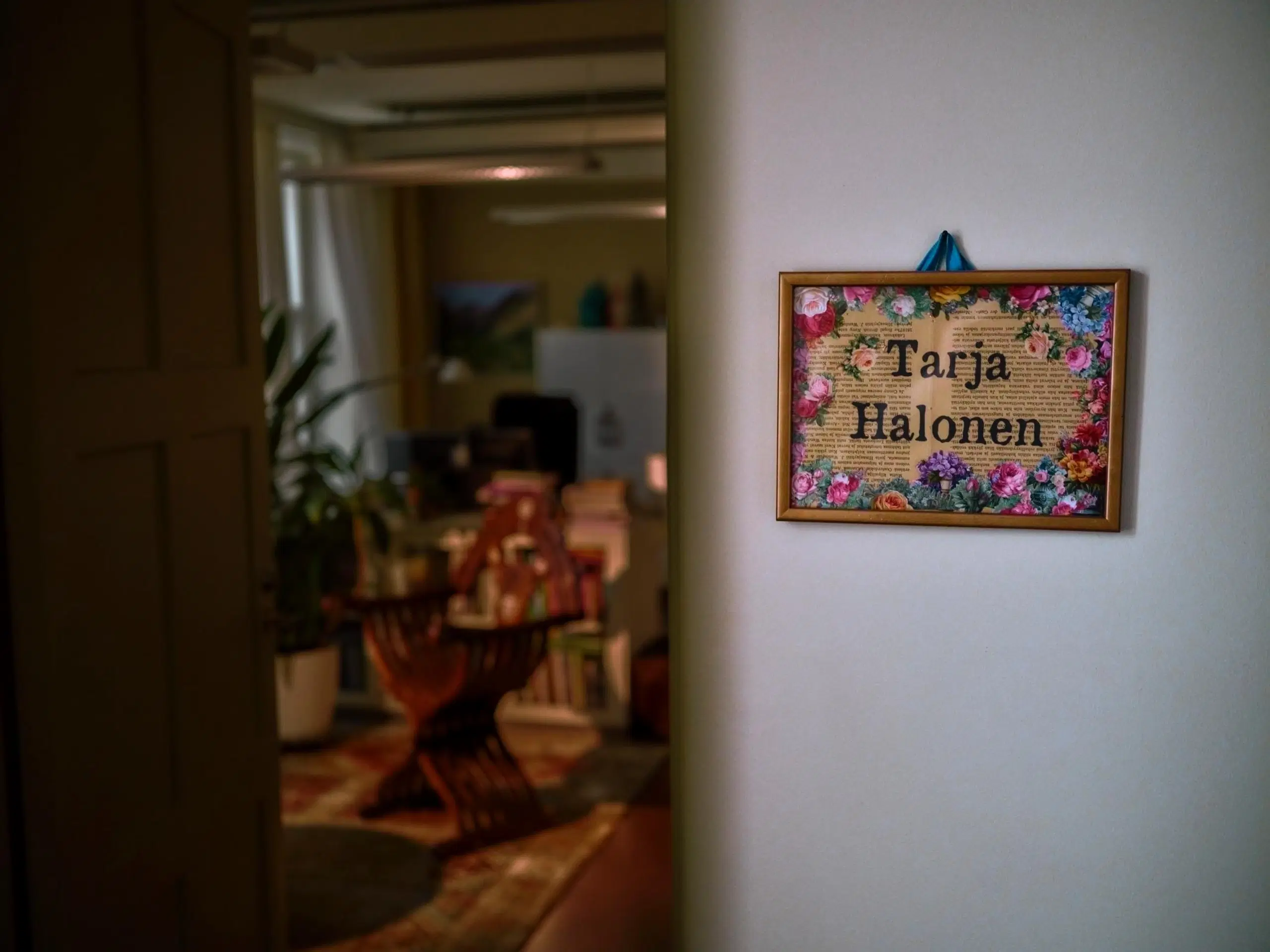 Ovenpielessä oleva kukkasin koristeltu kyltti, jossa lukee Tarja Halonen.