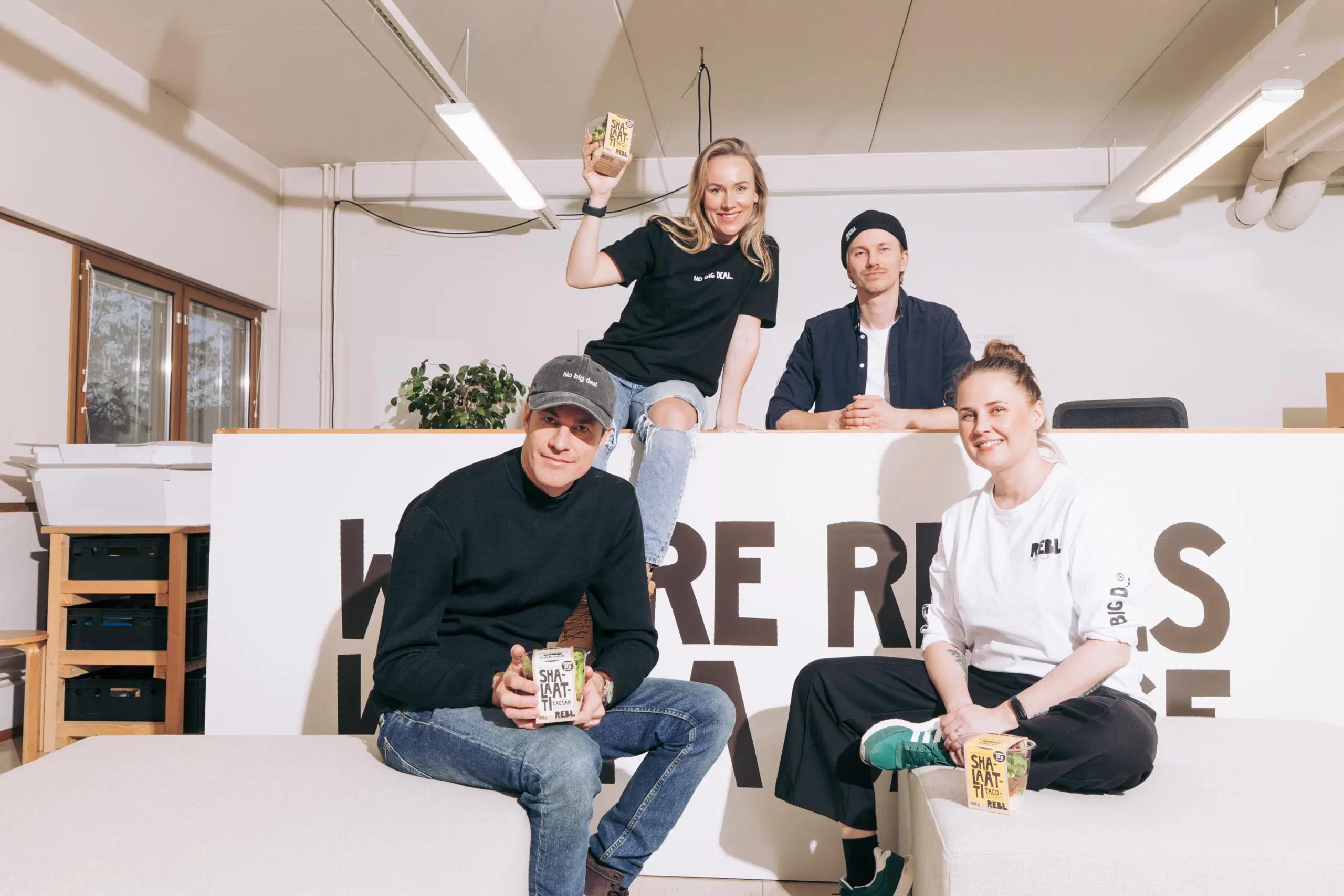 Martti Paatela, Elina Leskinen, Lauri Paatela ja Tiia Longi toimistoympäristössä. Kolme heistä esittelee Shalaatti-pakkausta.