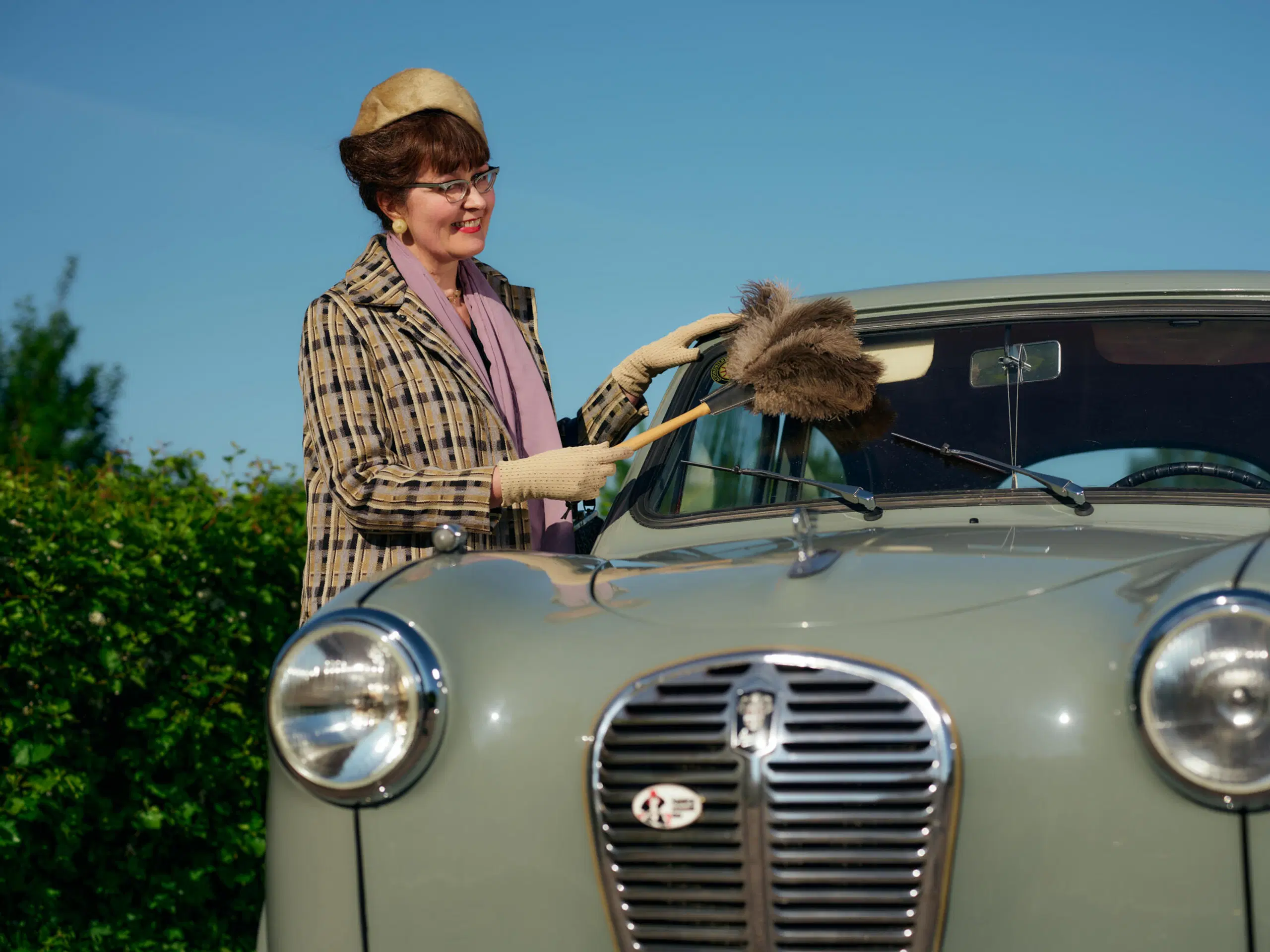 Tanja Virtanen-Leppä supsuttaa autoaan höyhenistä tehdyllä pölyhuiskalla.