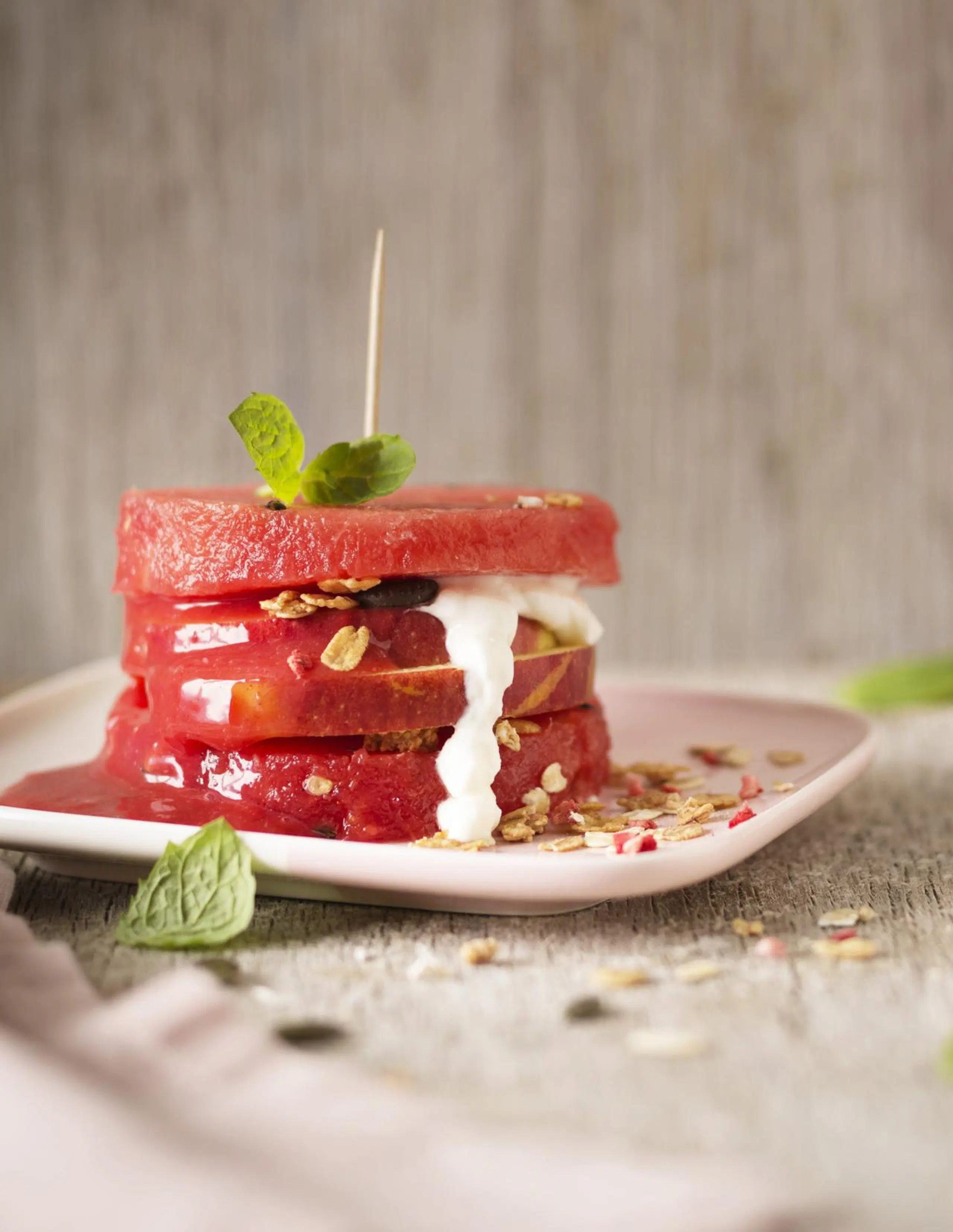 Meloniburgeri, jonka välissä omenaa, marjasosetta ja jogurttia