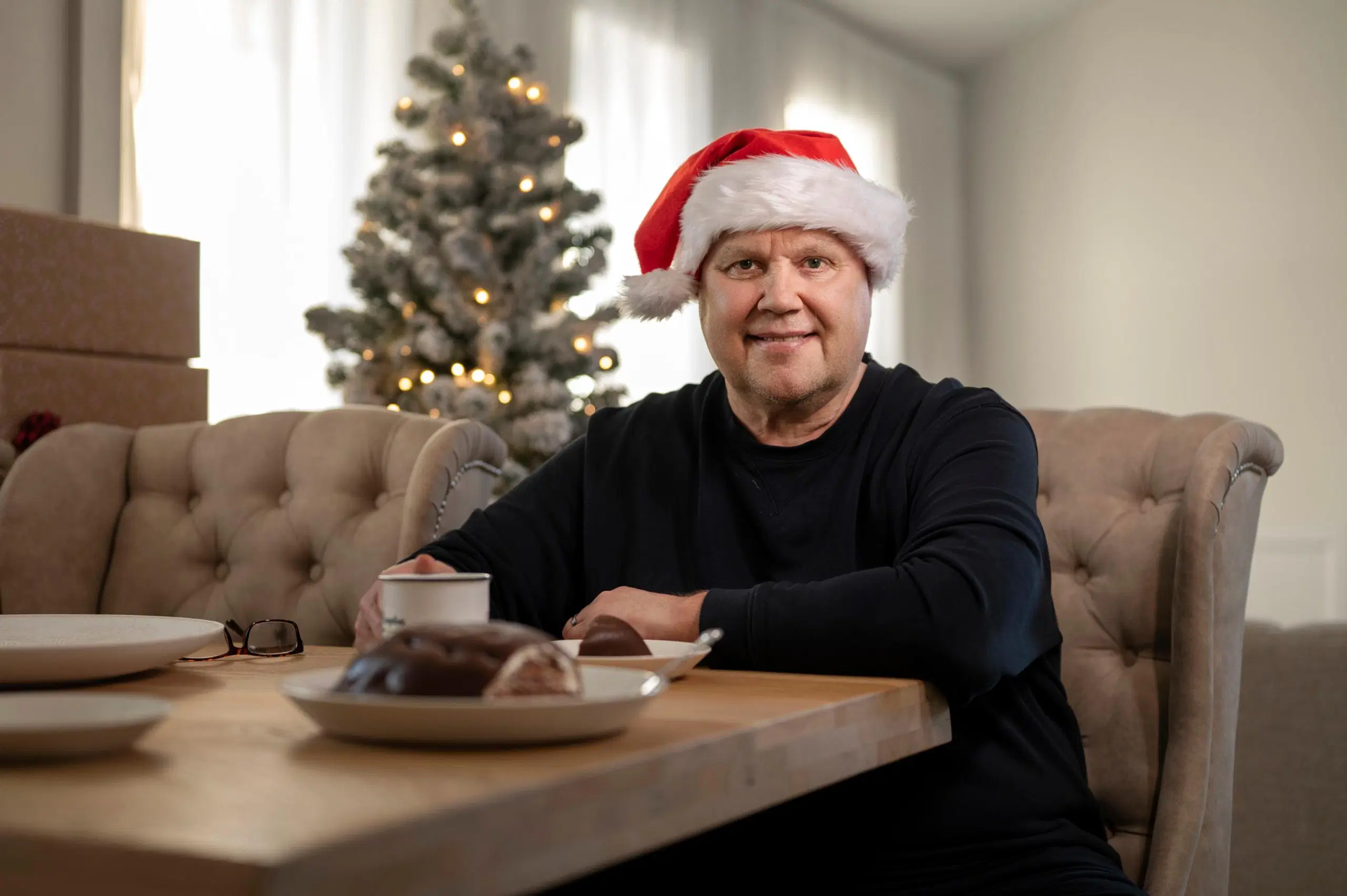 Timo Jutila pöydän ääressä tonttulakki päässä.