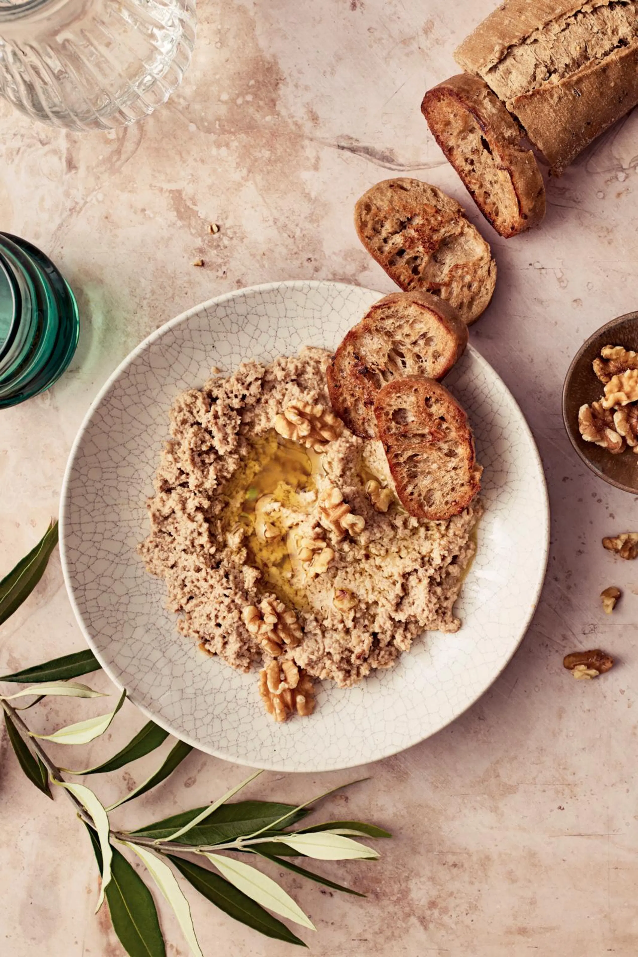 Saksanpähkinätahnaa lautasella. Paahdettua leipää vieressä.