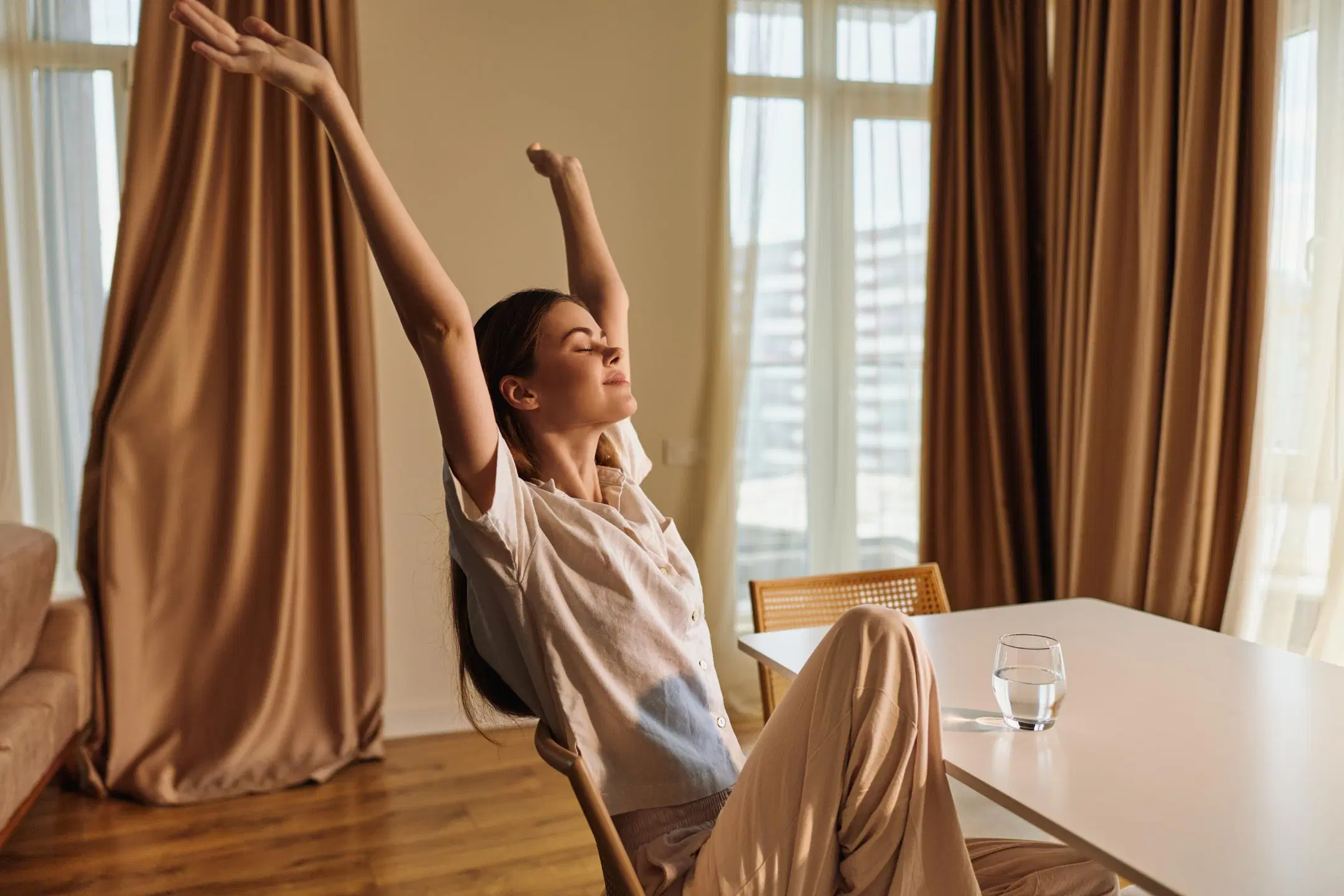 Rentoutunut nainen venyttelee pöydän ääressä