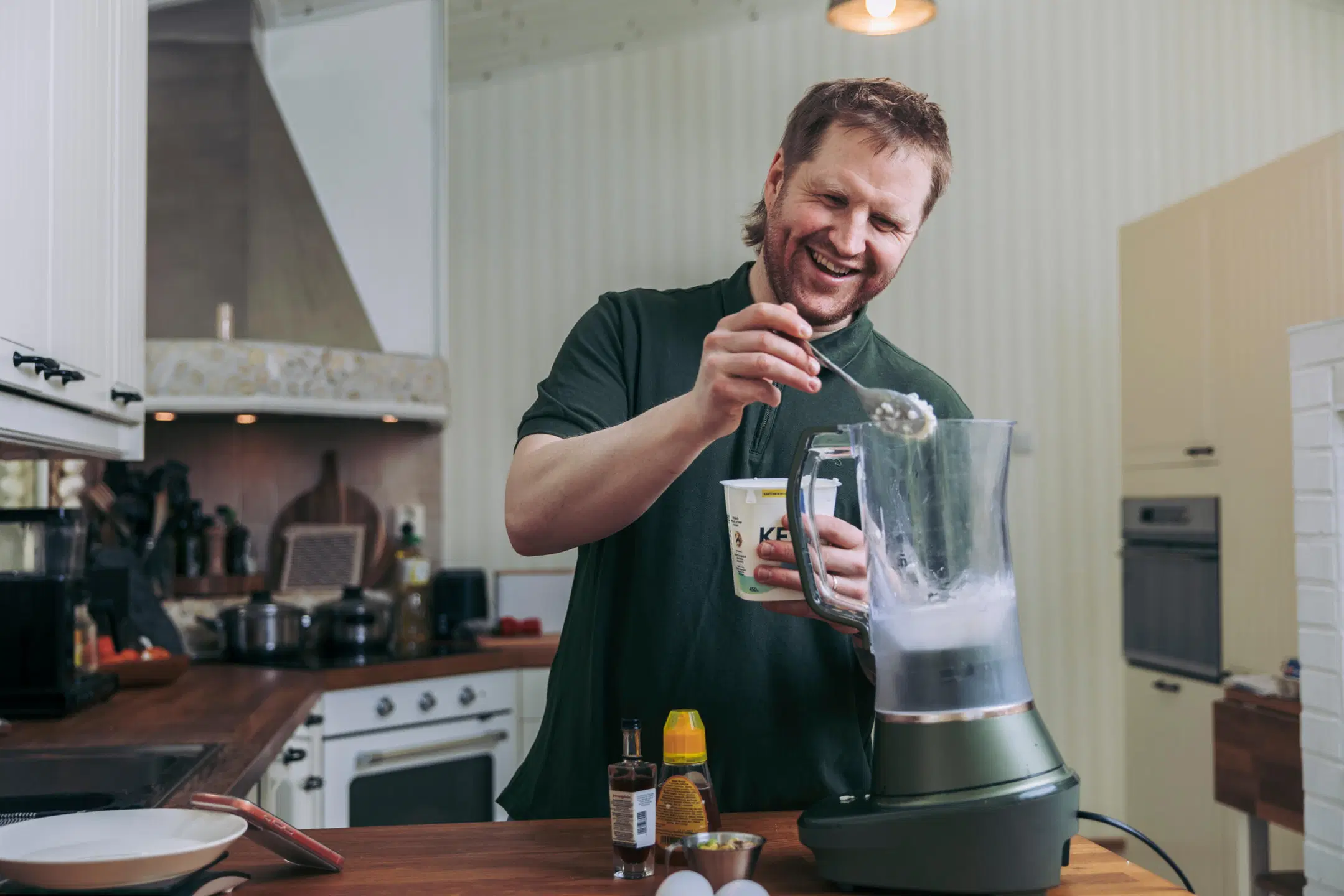 Tommi Manninen lusikoi raejuustoa tehosekoittimeen.