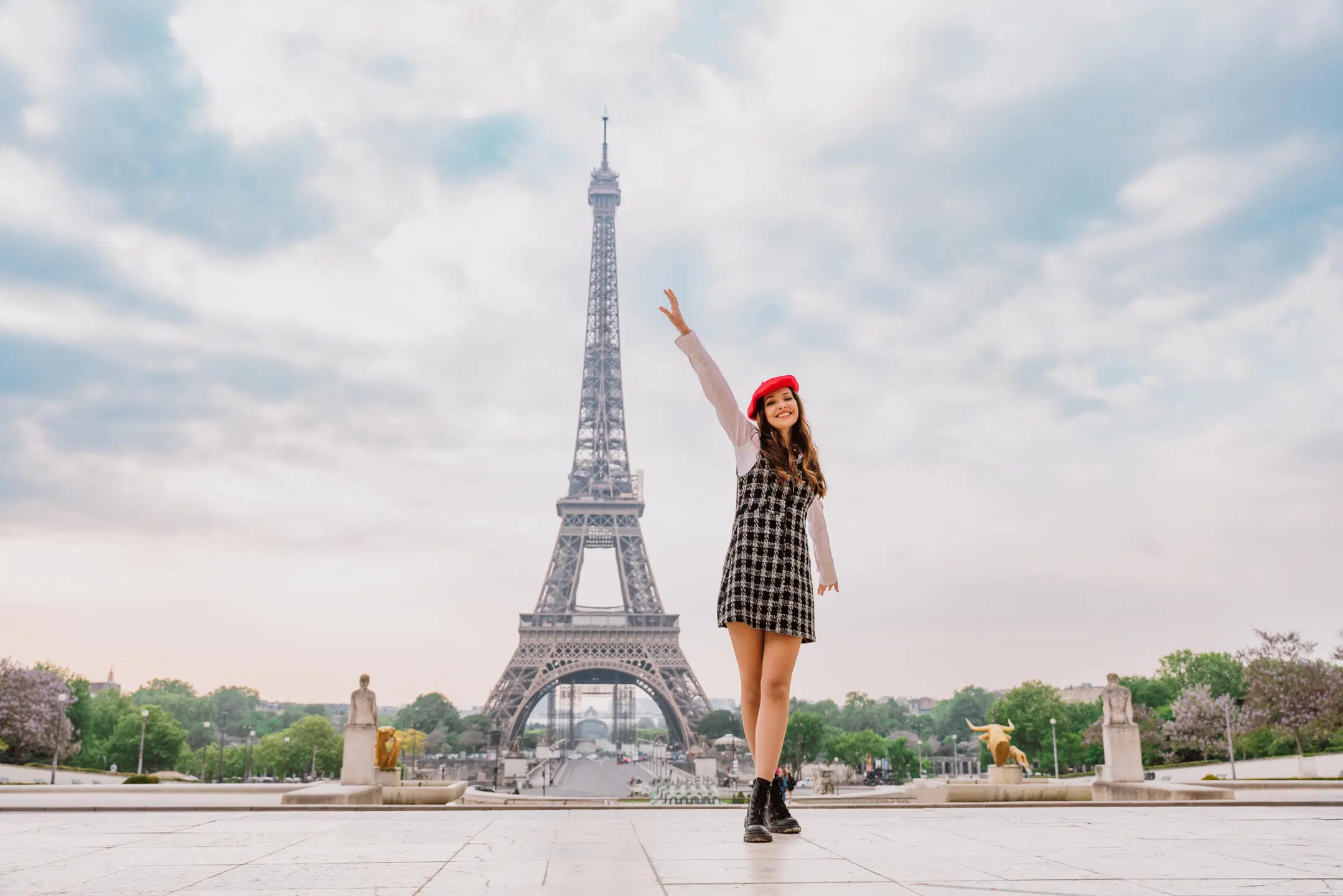 Tyylikkäästi pukeutunut nainen Eiffel-tornin vierellä