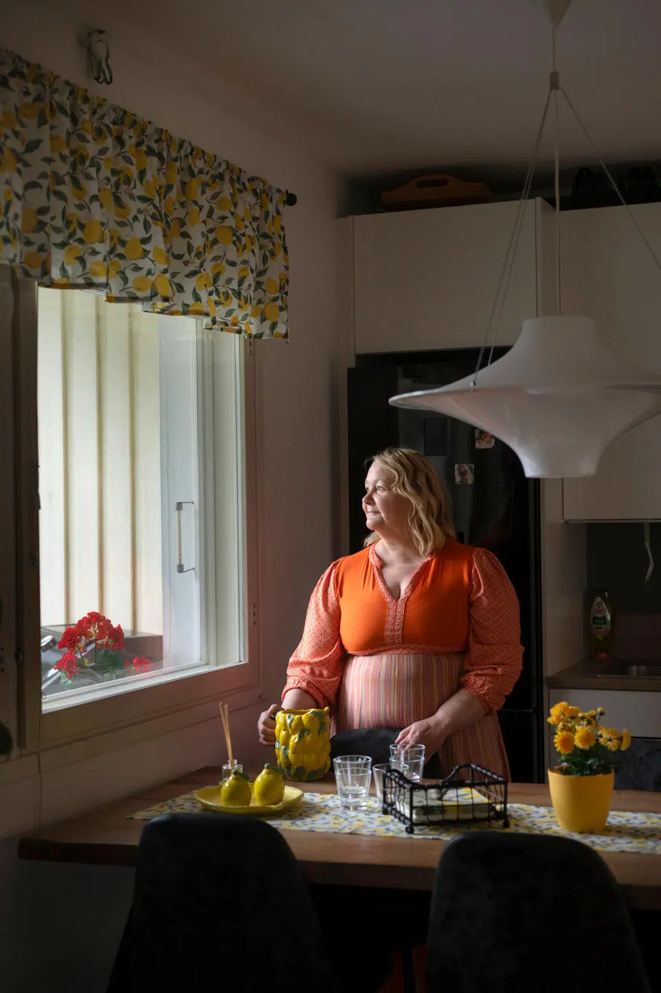 Anja Akkanen kuvattuna kotonaan ja kädessään sitruunakoristeinen kannu.