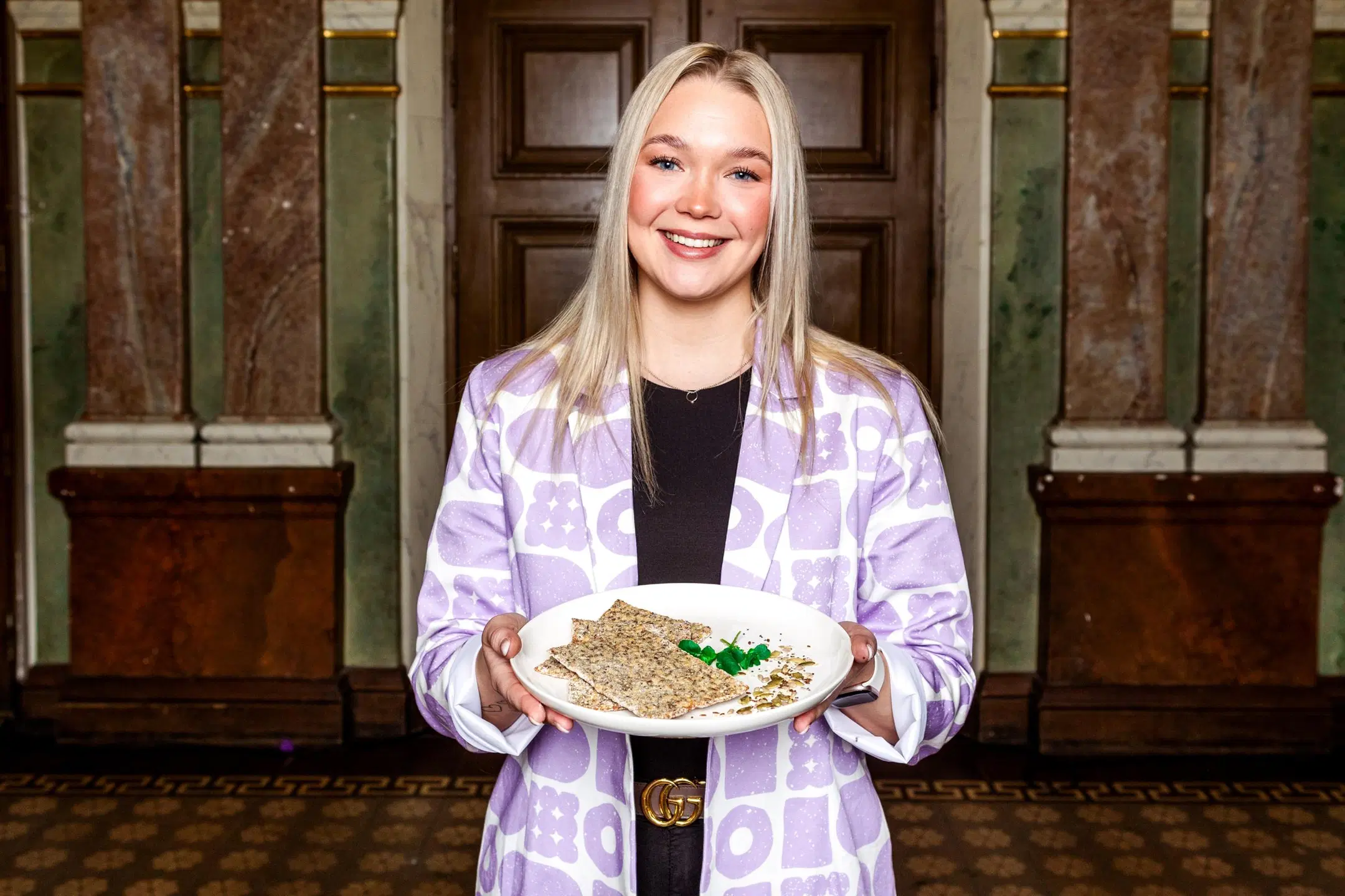 Iita Tyykiluoto käsissään lautanen, jolla on kolme siemenrieskaa