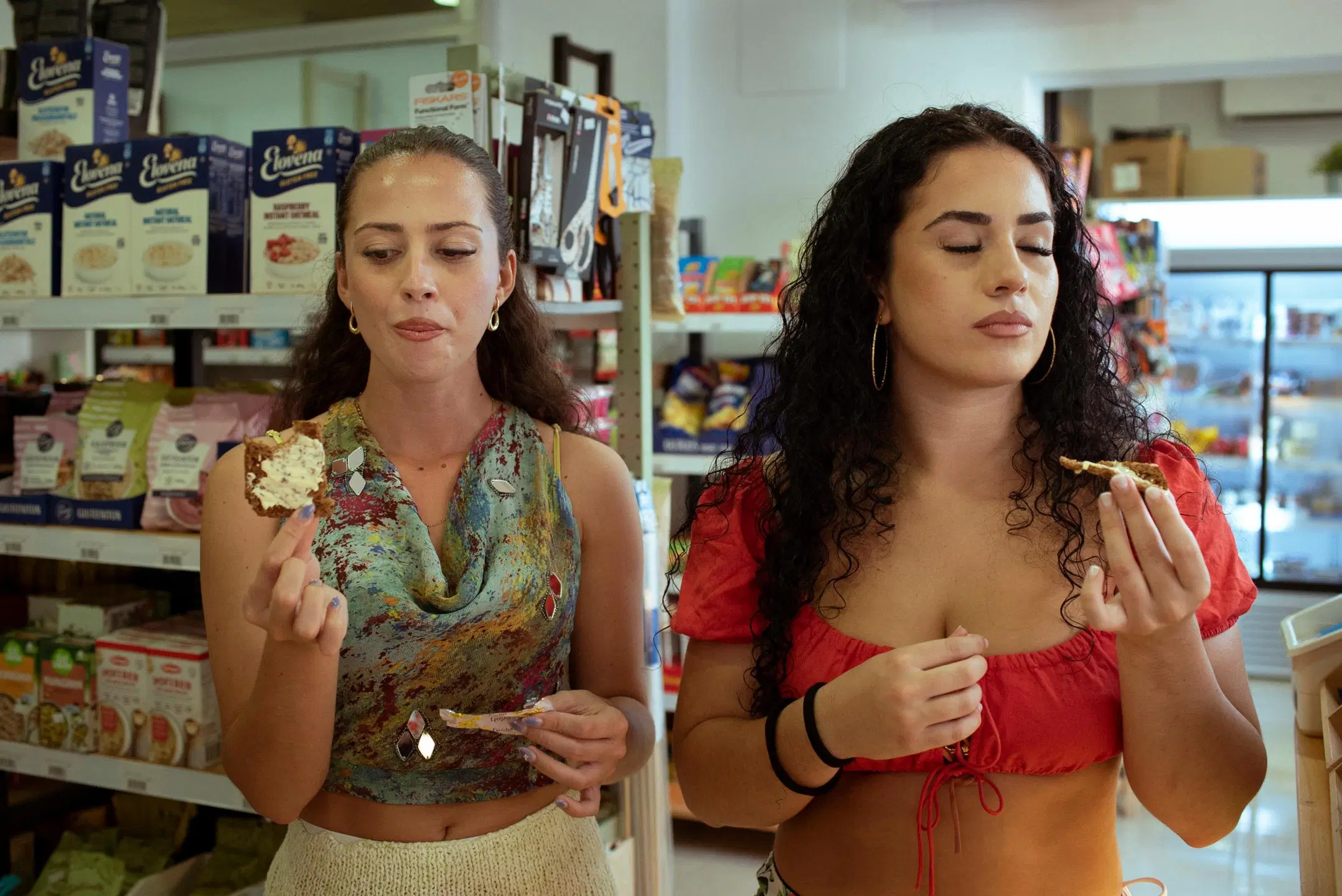 Kaksi nuorta naista maistelee ruisleipää kaupassa