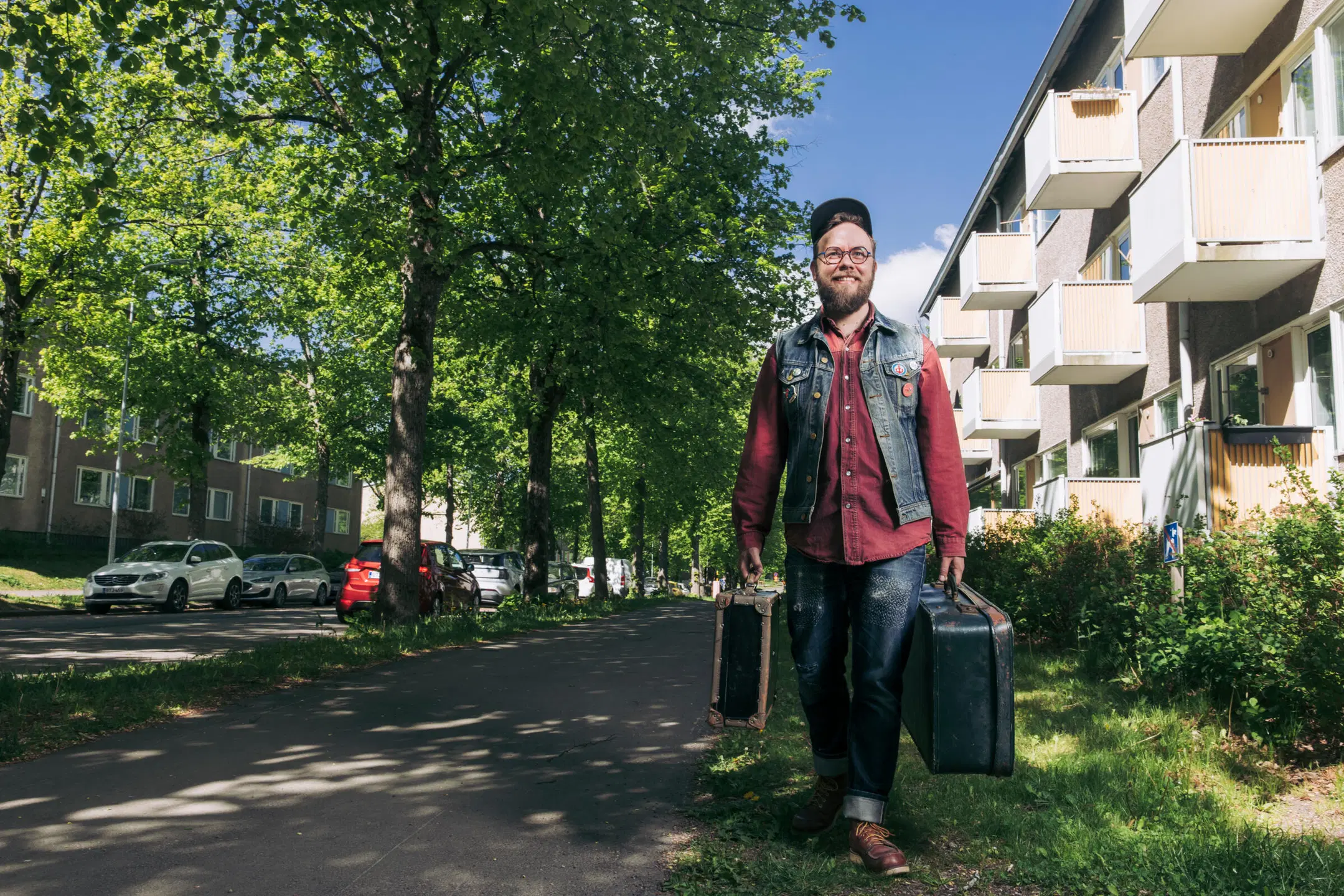 Niko Lindgren kävelee jalkakäytävällä ja kantaa kahta matkalaukkua.