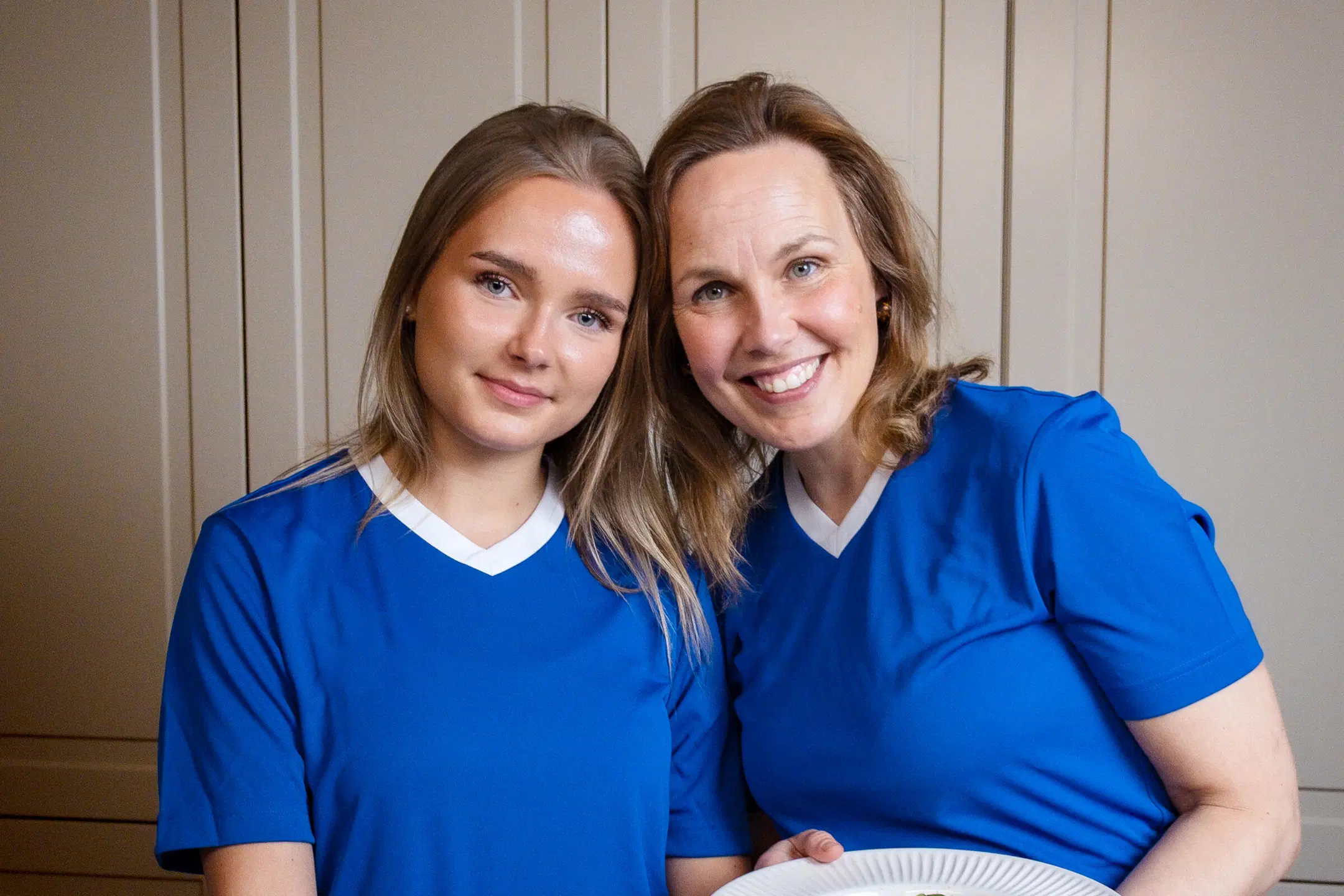 Sofia Eranka pitelee käsissään jalkapalloa ja äiti Essi Eranka lautasta, jossa on pasta capresea. Vaakakuva.
