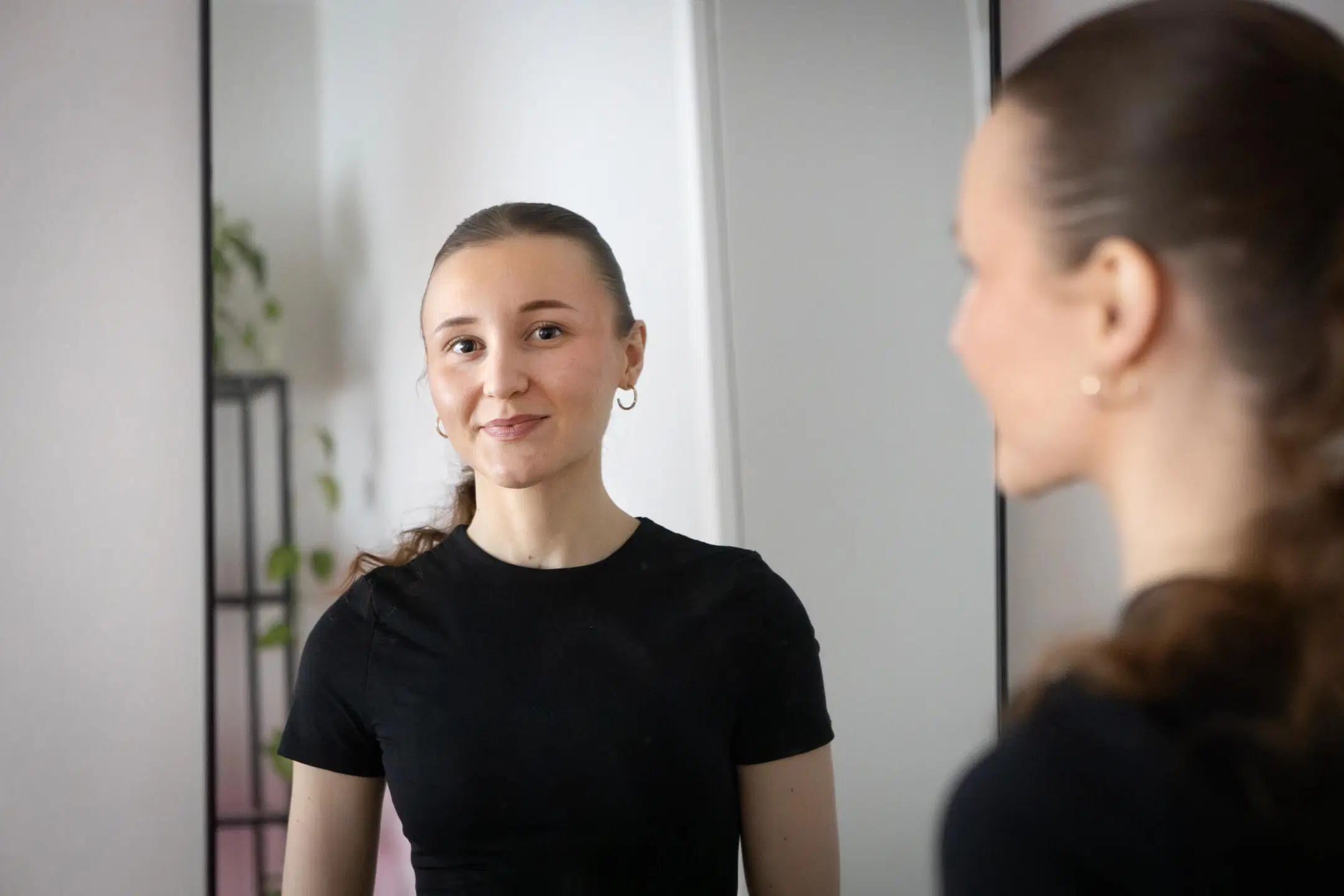 Ina Mattila katsoo peiliin, sieltä heijastuvat hänen kasvonsa.