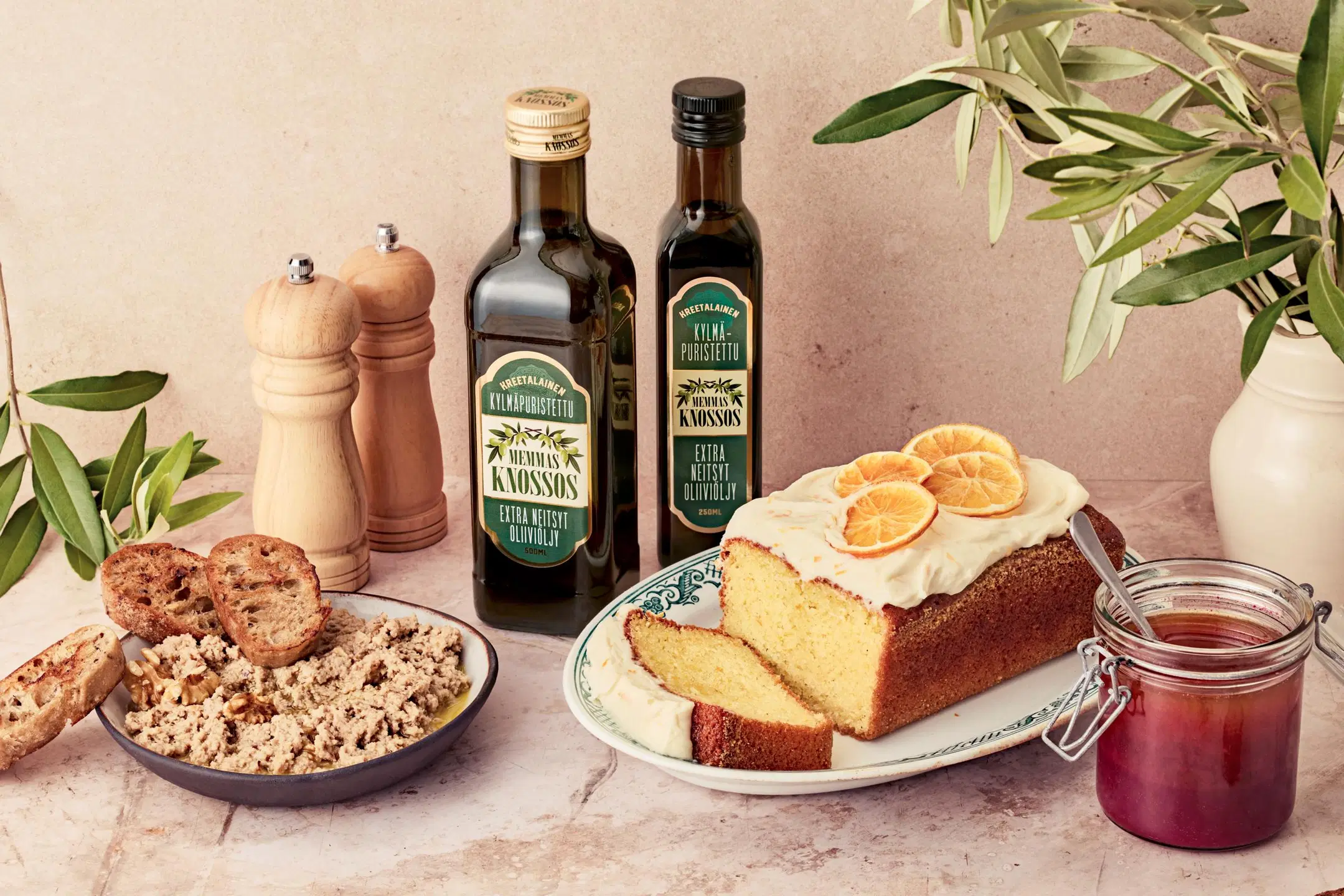 Pöydällä memmas knossos oliiviöljyä sekä saksanpähkinätahnaa, granaattiomenavinegretteä ja appelsiinikakkua.